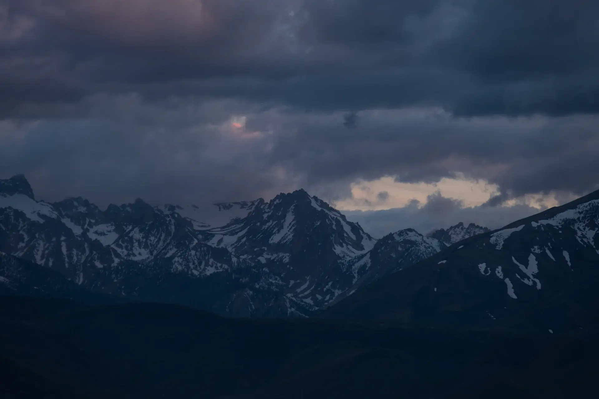 Lone figure standing before a vast, mist-wrapped mountain valley