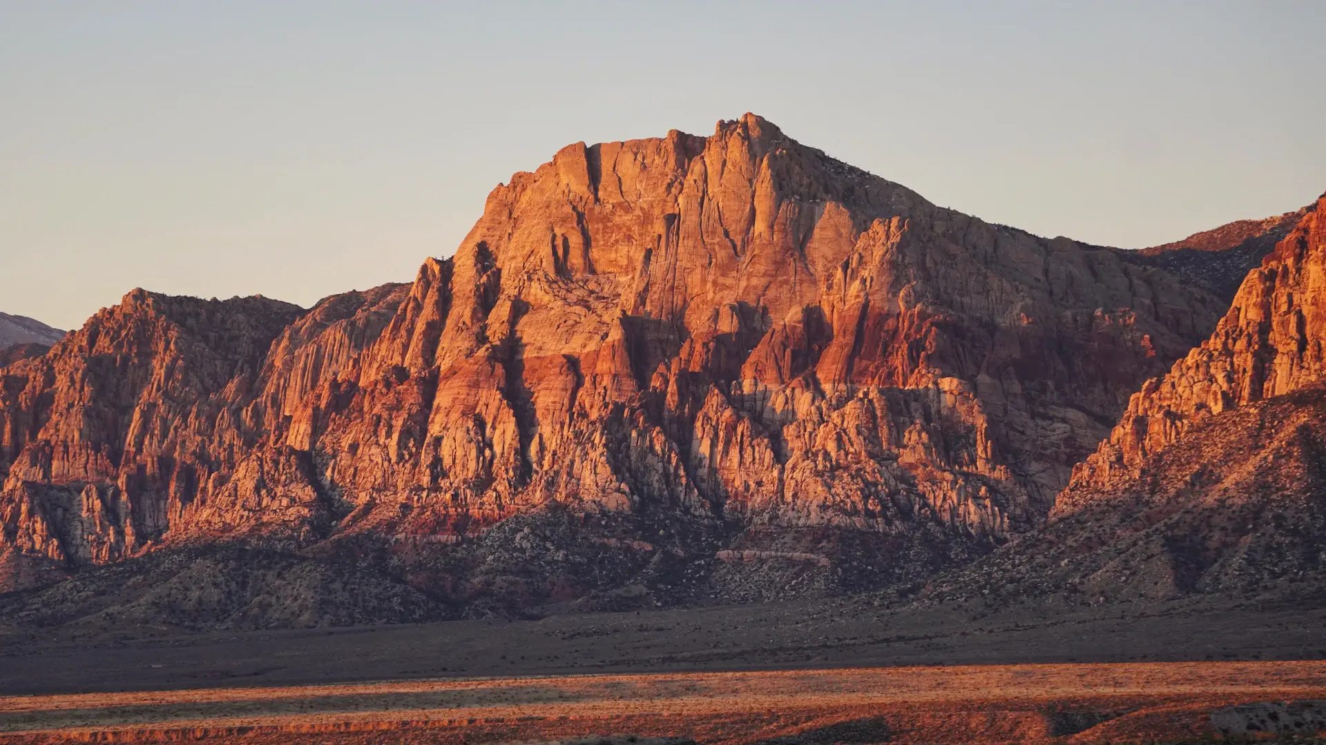 Cracked dry earth meeting distant desert mountains