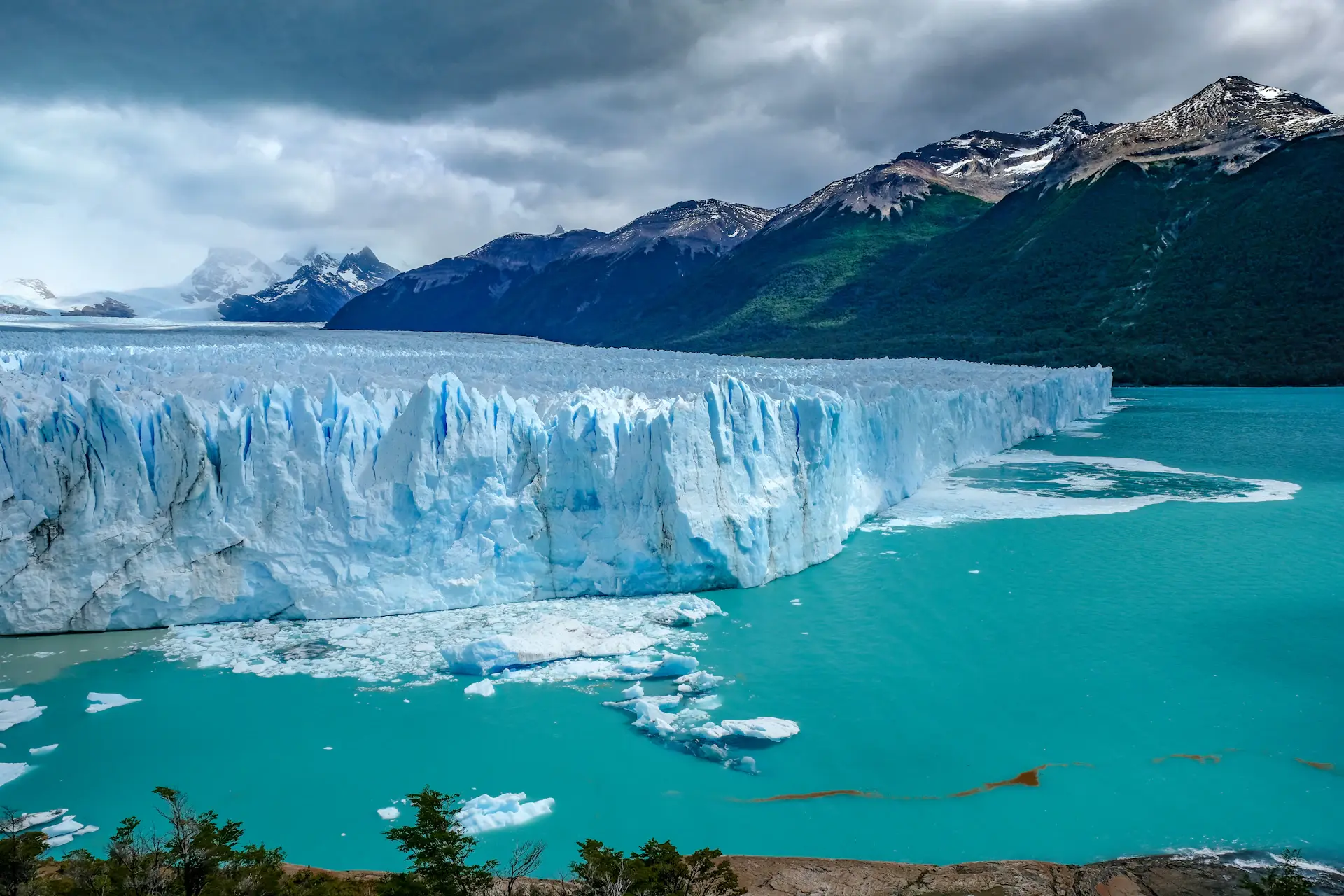 A lone figure standing before a vast glacier at dawn in Patagonia