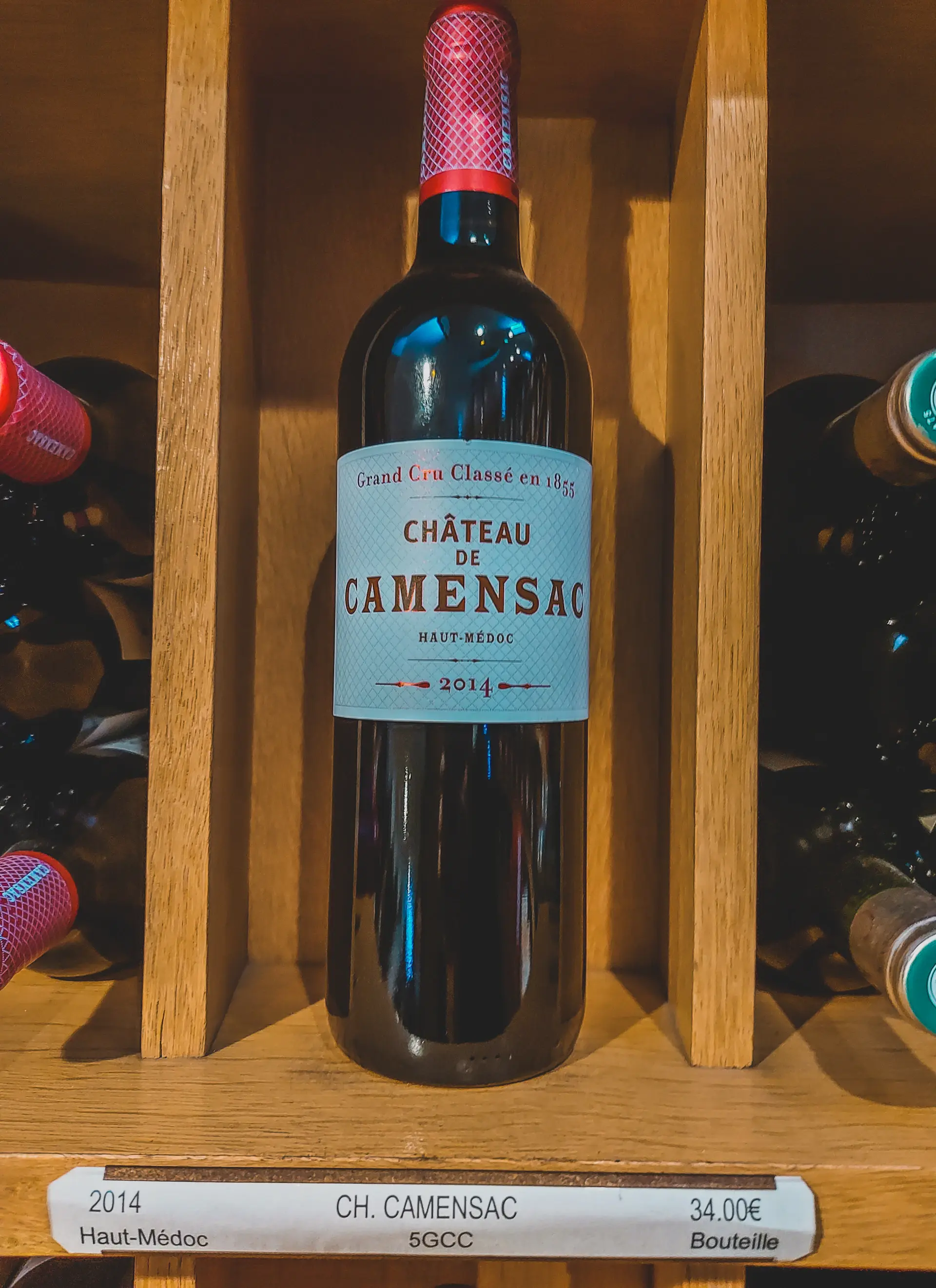 A rare aged Bordeaux bottle lit dramatically against a dark champagne-gold backlight