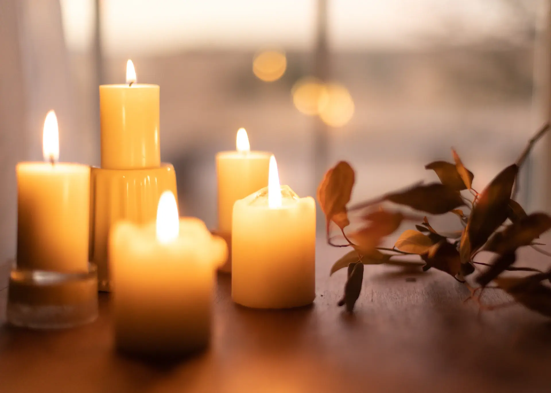 Cluster of lit candles in golden holders on a wedding table