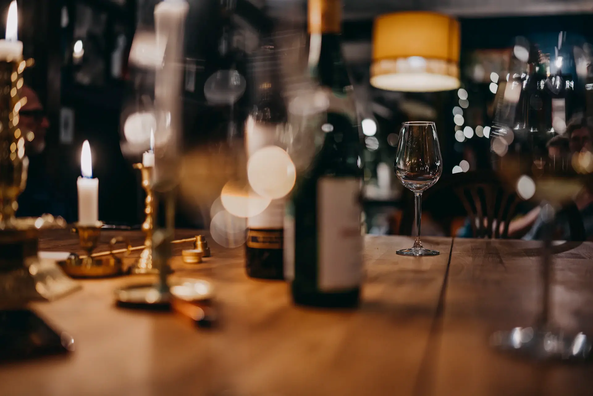 A refined pour of wine in a candlelit private cellar setting
