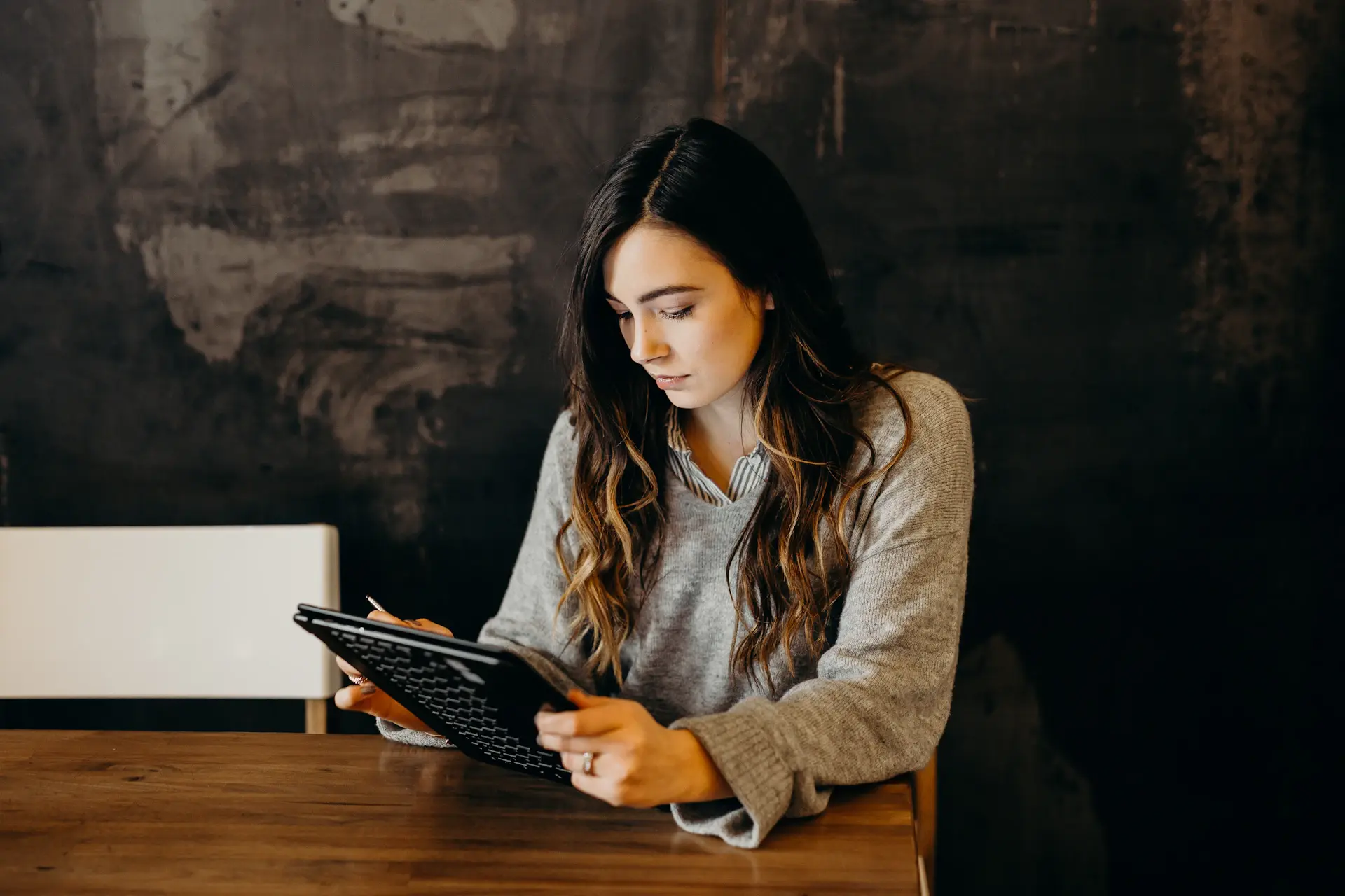 A young founder reviewing finances on a tablet in a bright, modern workspace