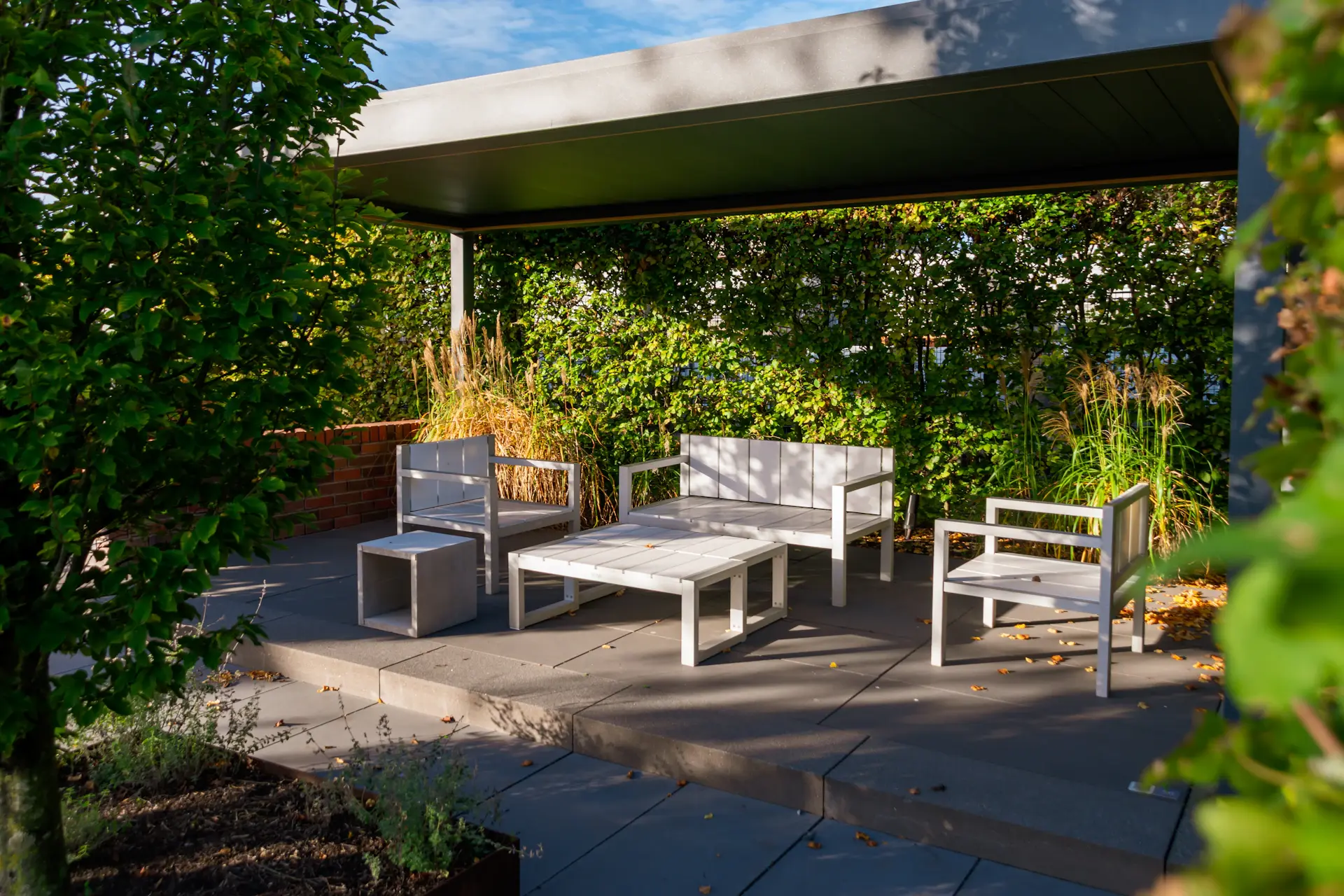 A sunlit garden terrace set for an outdoor ceremony