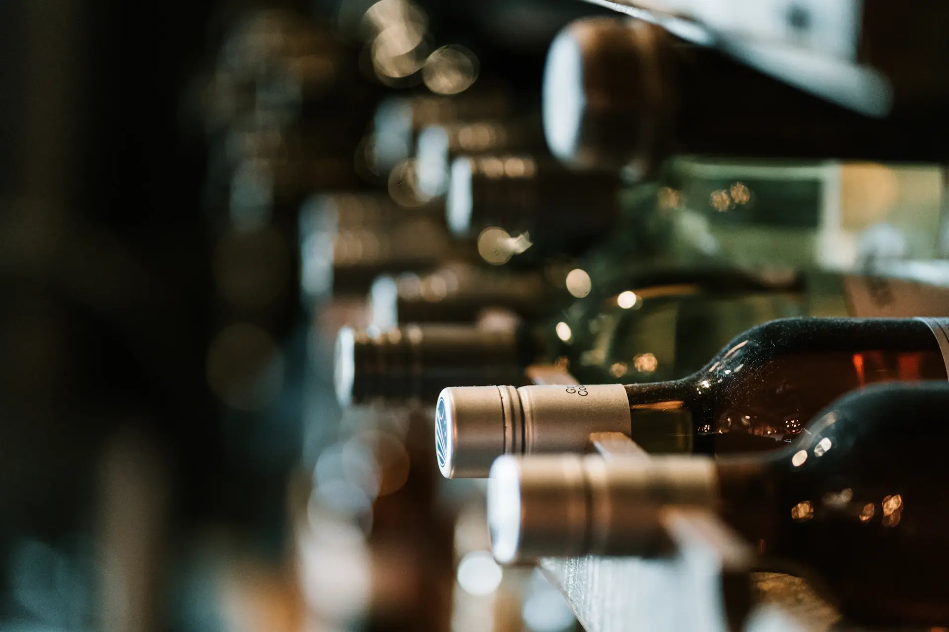 Rare bottles resting on their sides in a private cellar rack