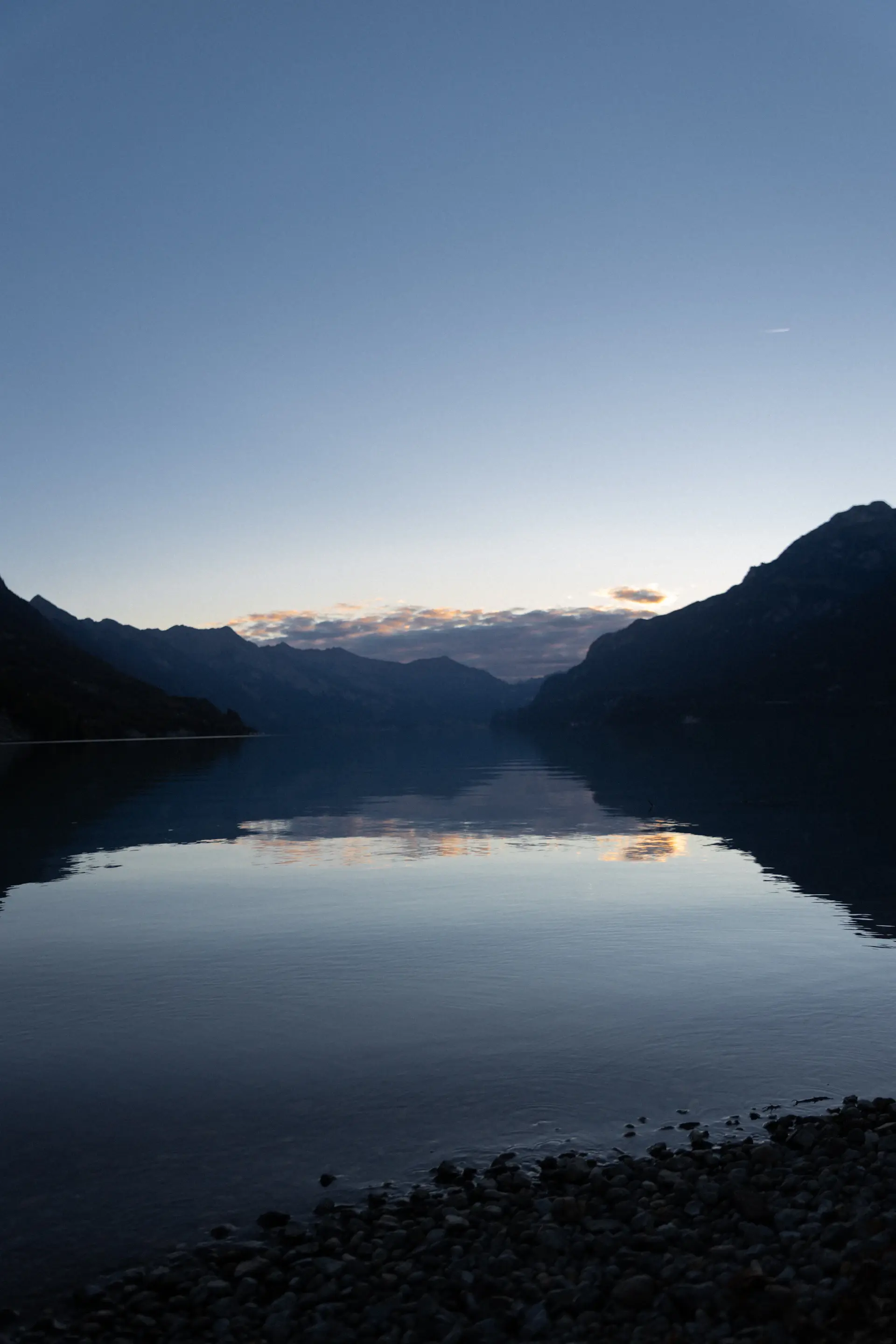 A perfectly still alpine lake reflecting the evening sky