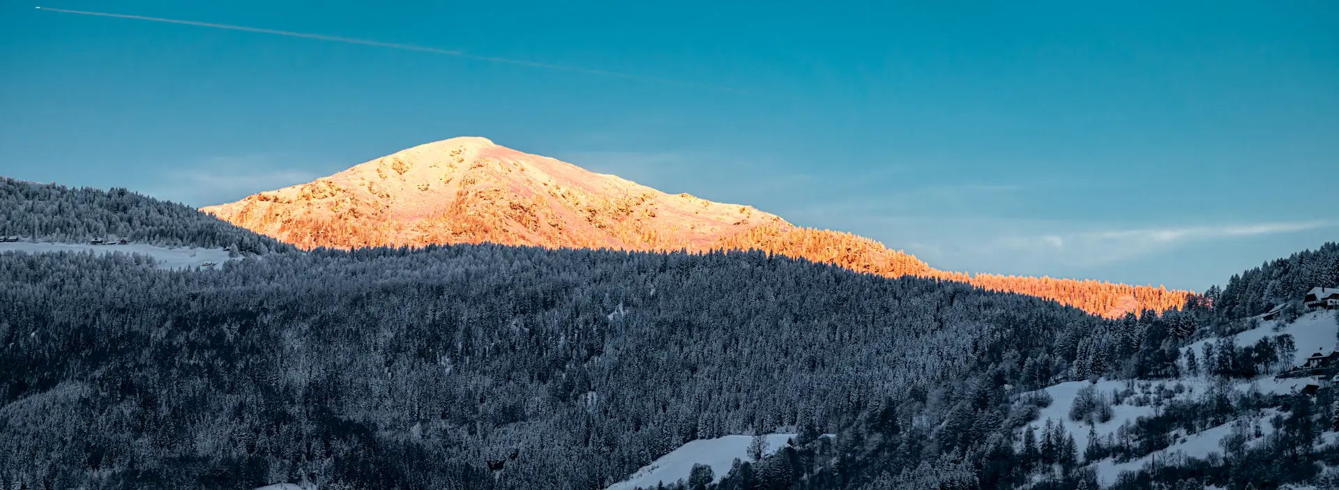 Snow-laden peaks under a pale, silent winter sky