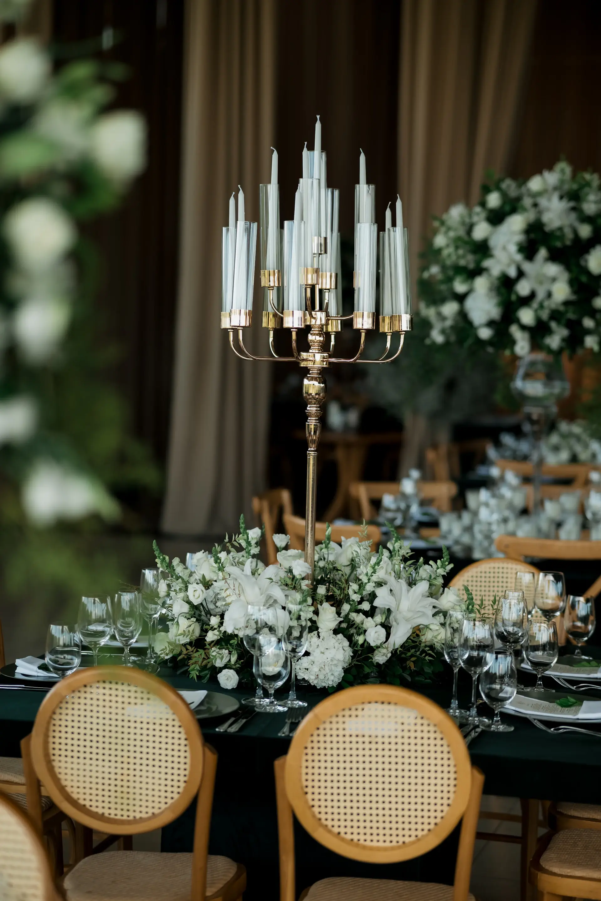 Elegant banquet table dressed with white roses, gold accents and candlelight