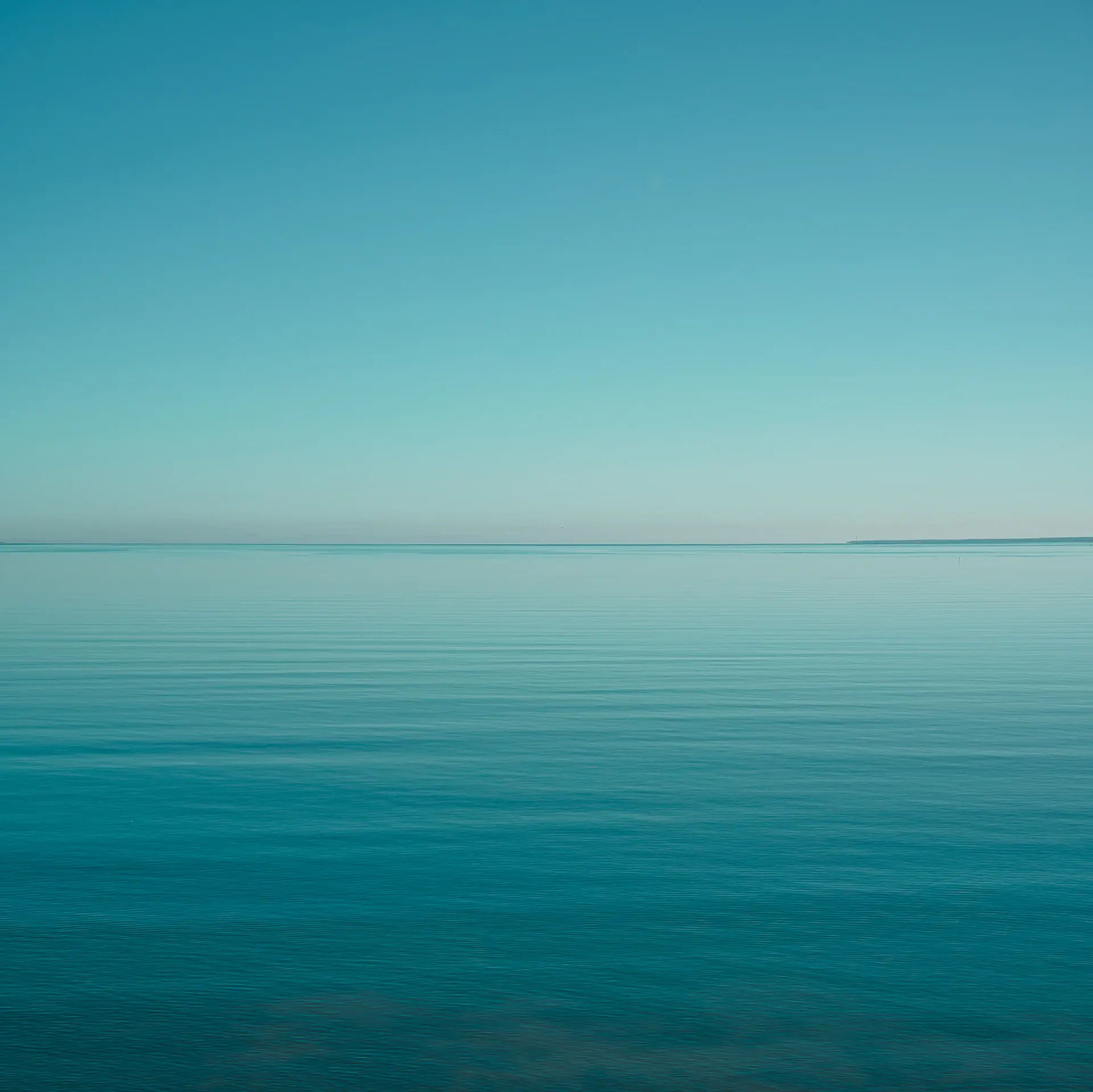 Calm grey ocean meeting a soft pale horizon
