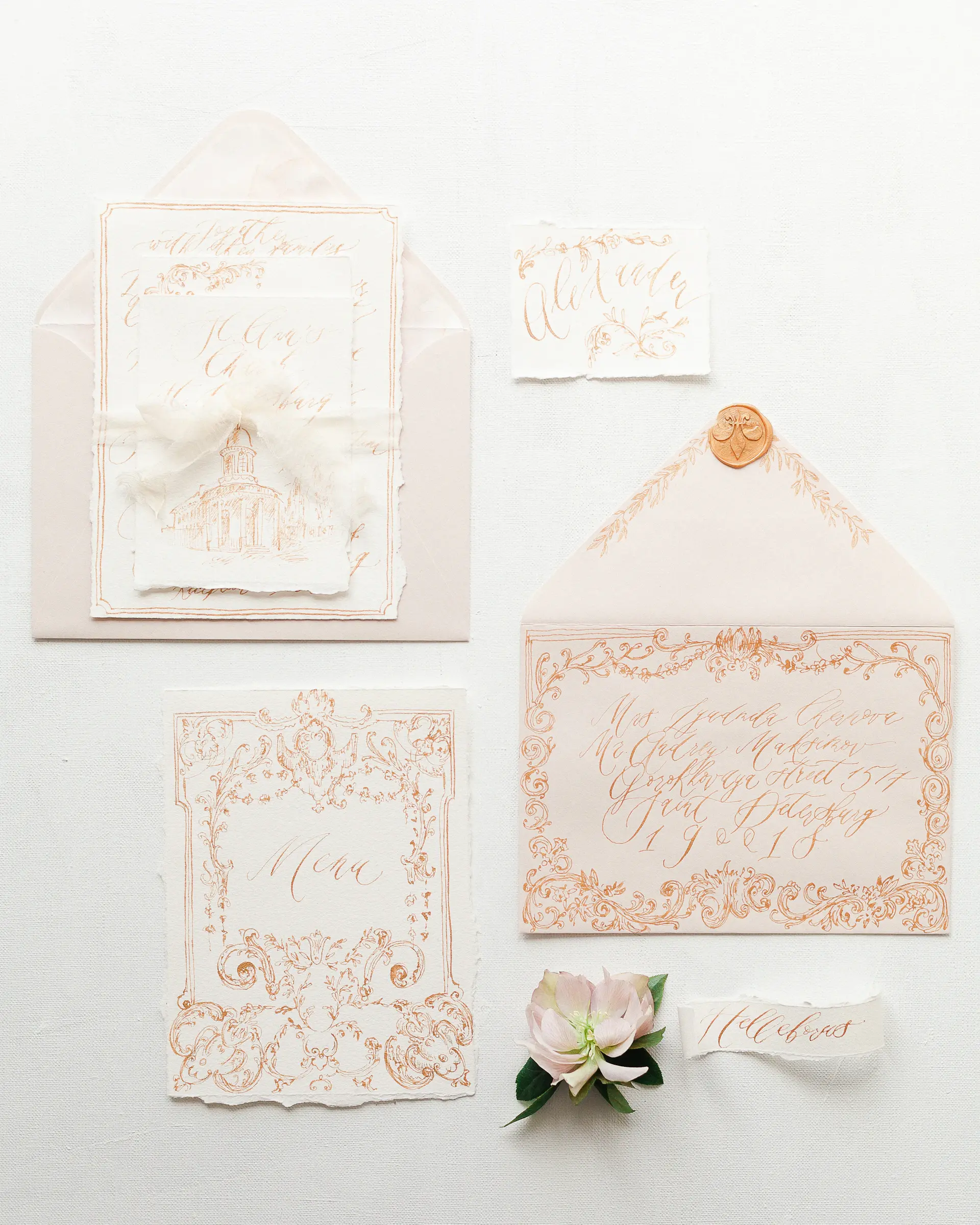 A close detail of gilded wedding stationery and white florals