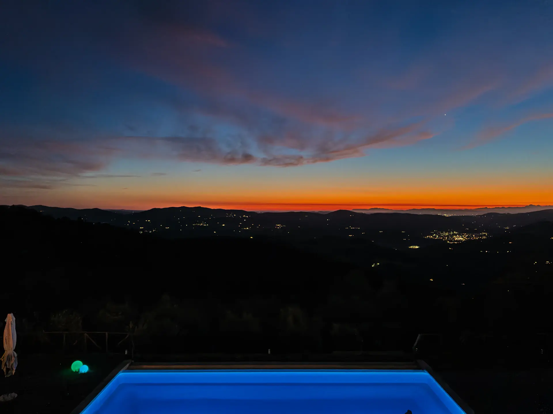 Infinity-edge pool deck at twilight with lounge seating