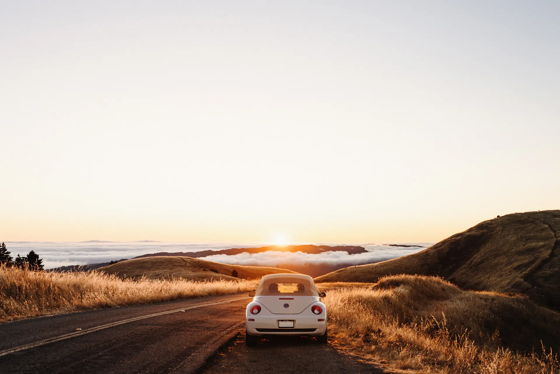 A luxury motorcar on an empty Highland road at dawn