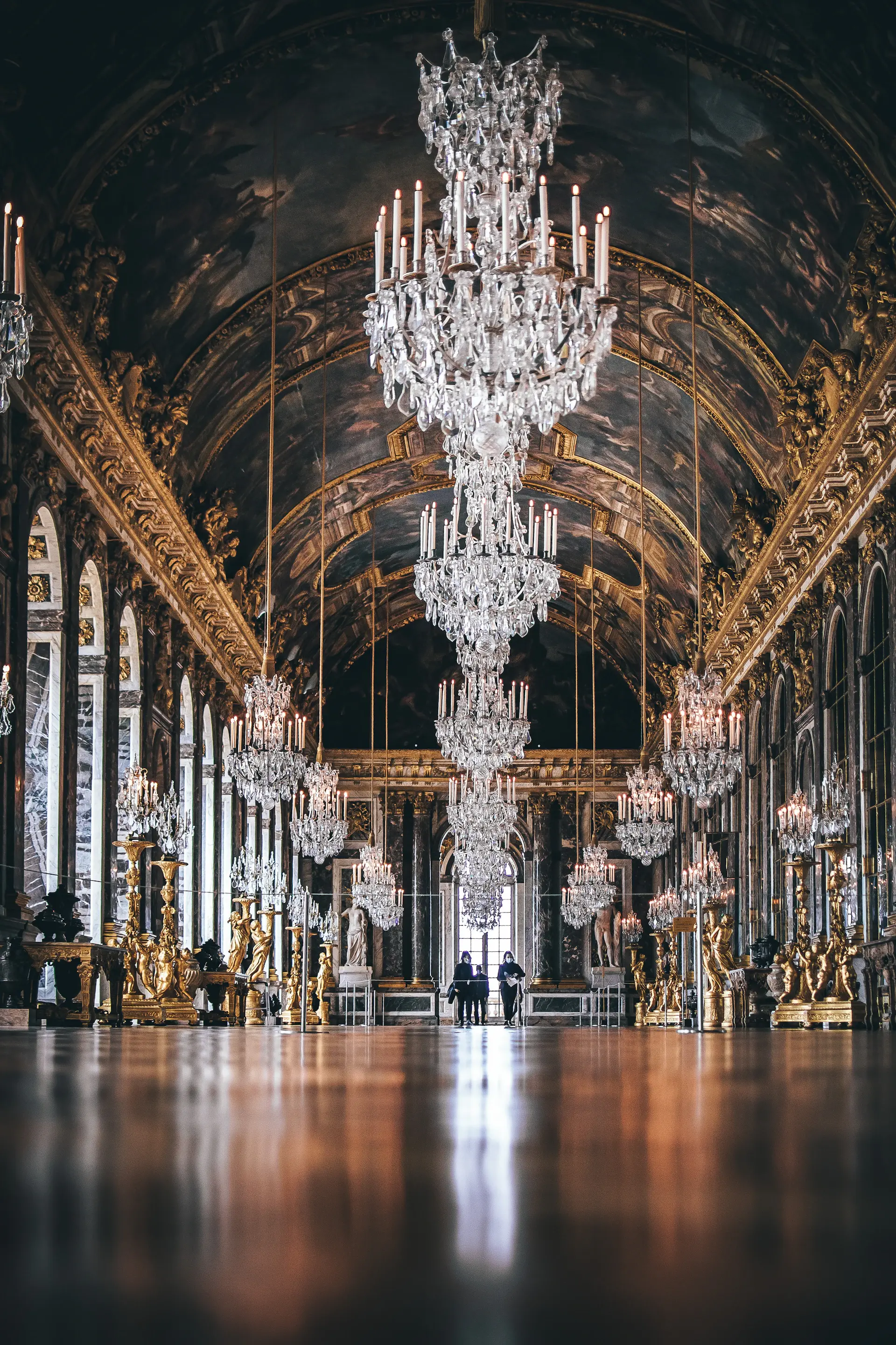 Grand palace ballroom with crystal chandeliers and a long banquet table set for a royal wedding