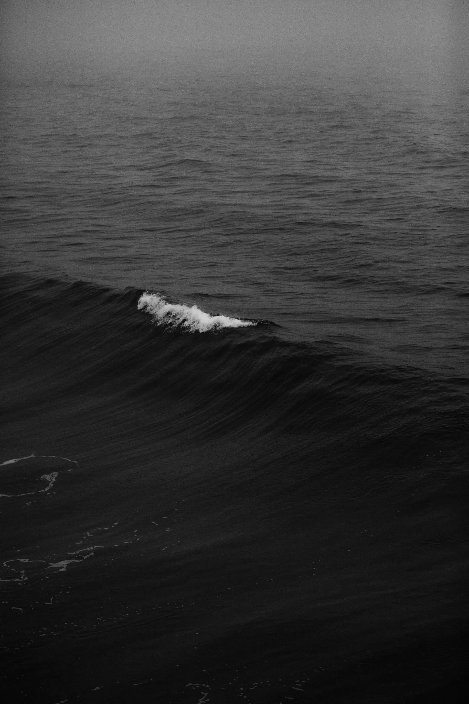 Waves folding over a black volcanic shore