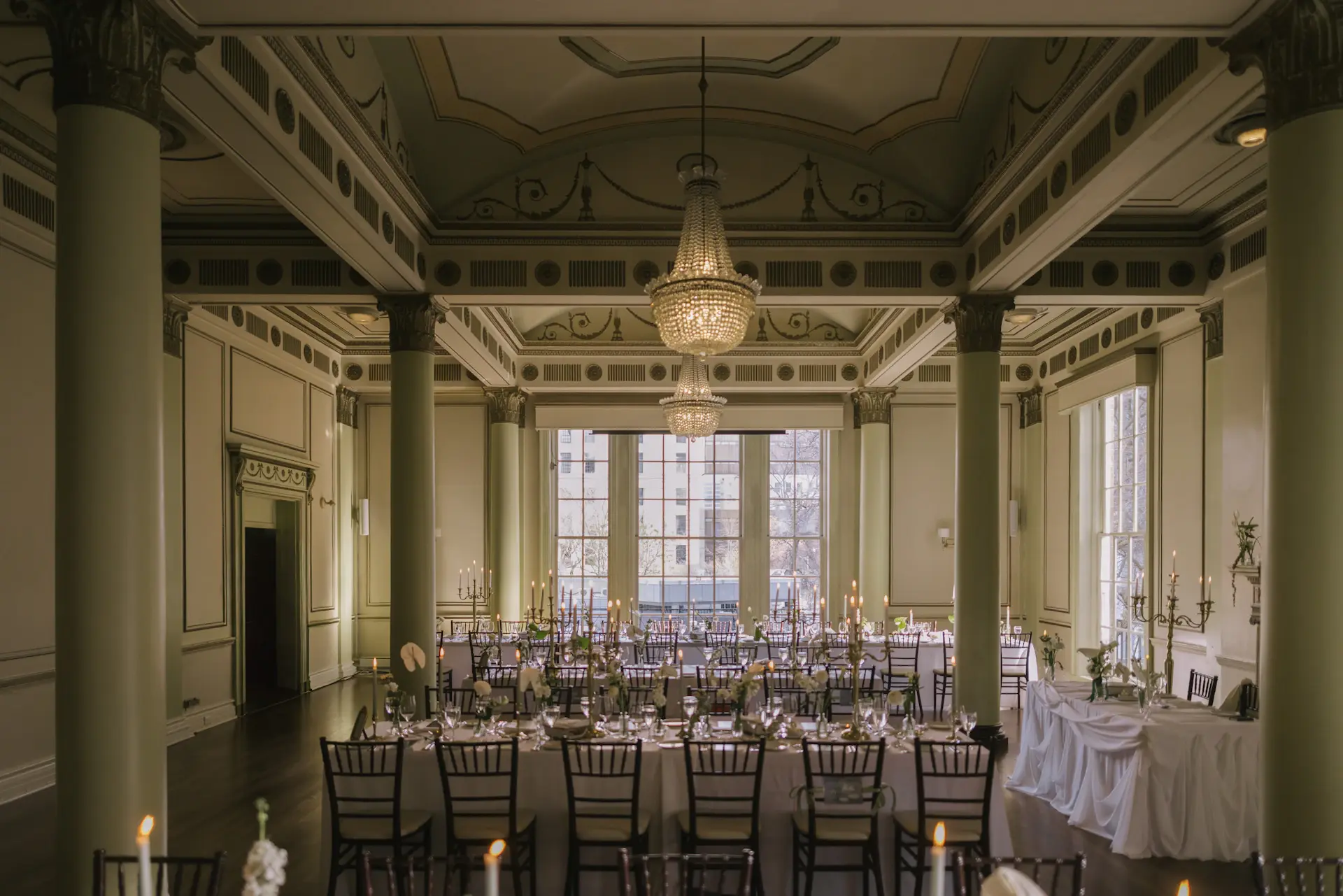 A grand candlelit ballroom set for a wedding reception