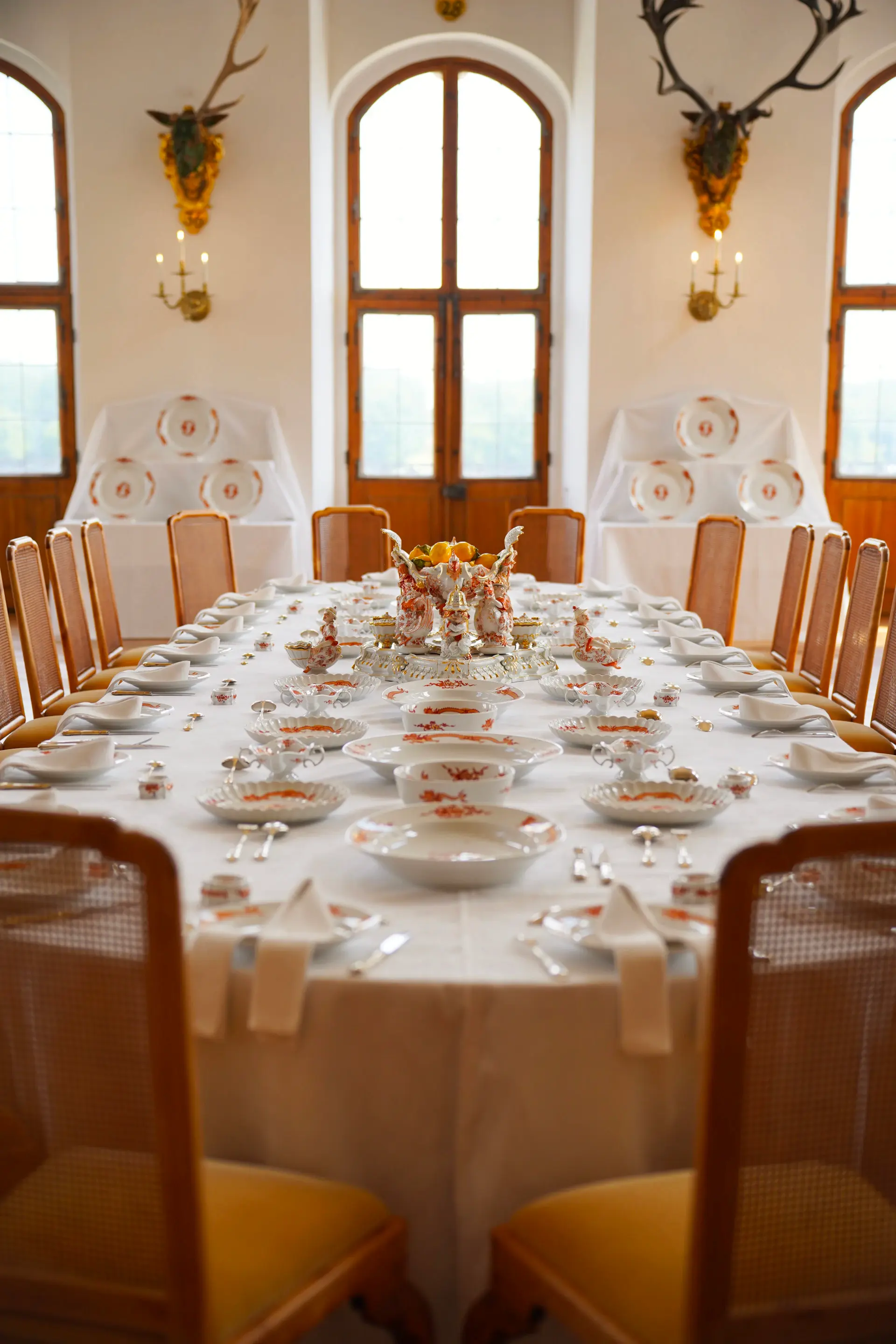 Elegant banquet table set with gold-rimmed china and candlelight