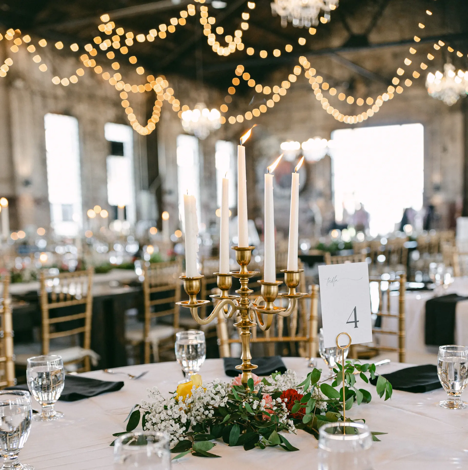 Close-up of a candlelit table setting in gold