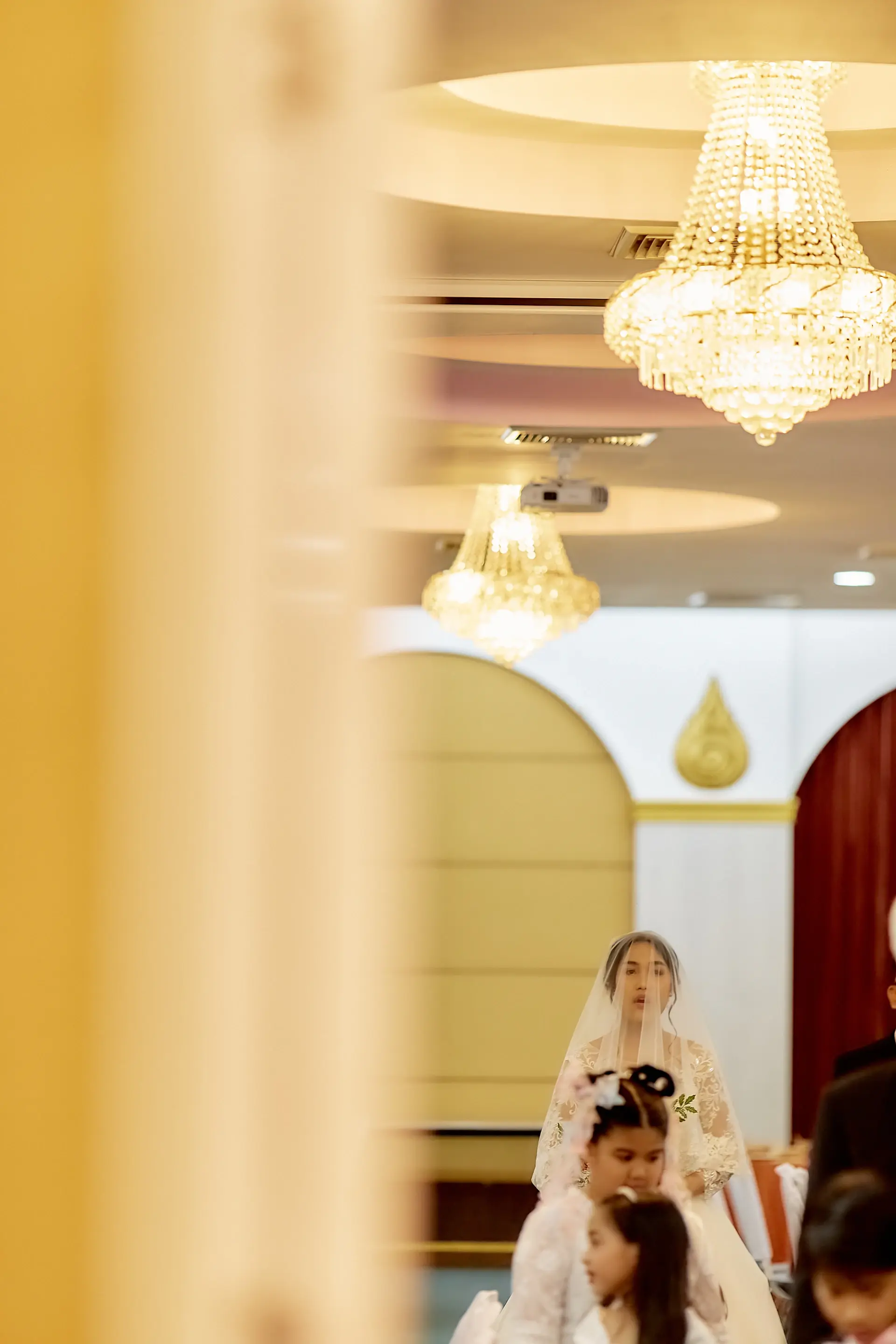 A couple sharing their first dance beneath palace chandeliers