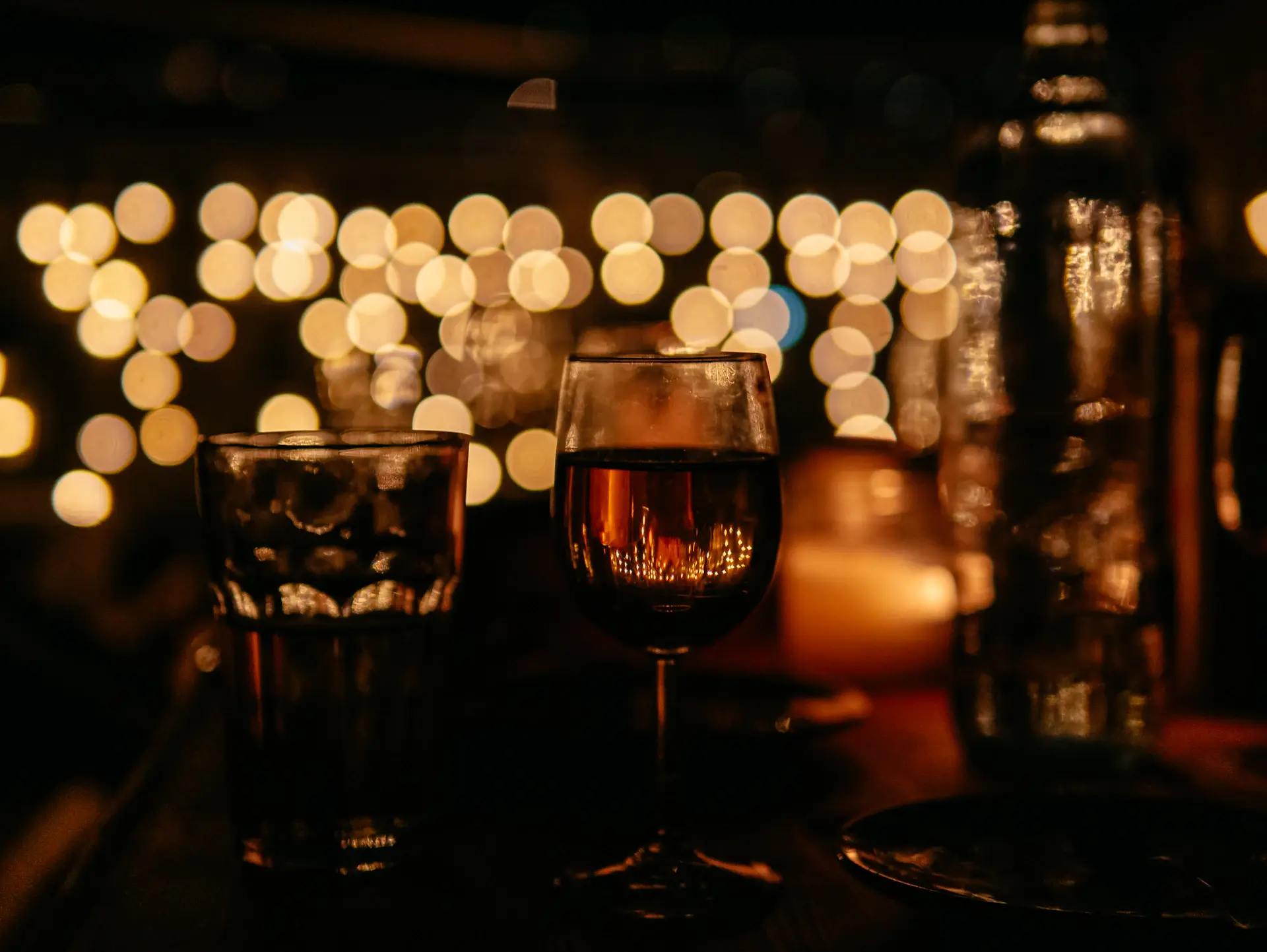 A tasting glass catching warm light on a dark table