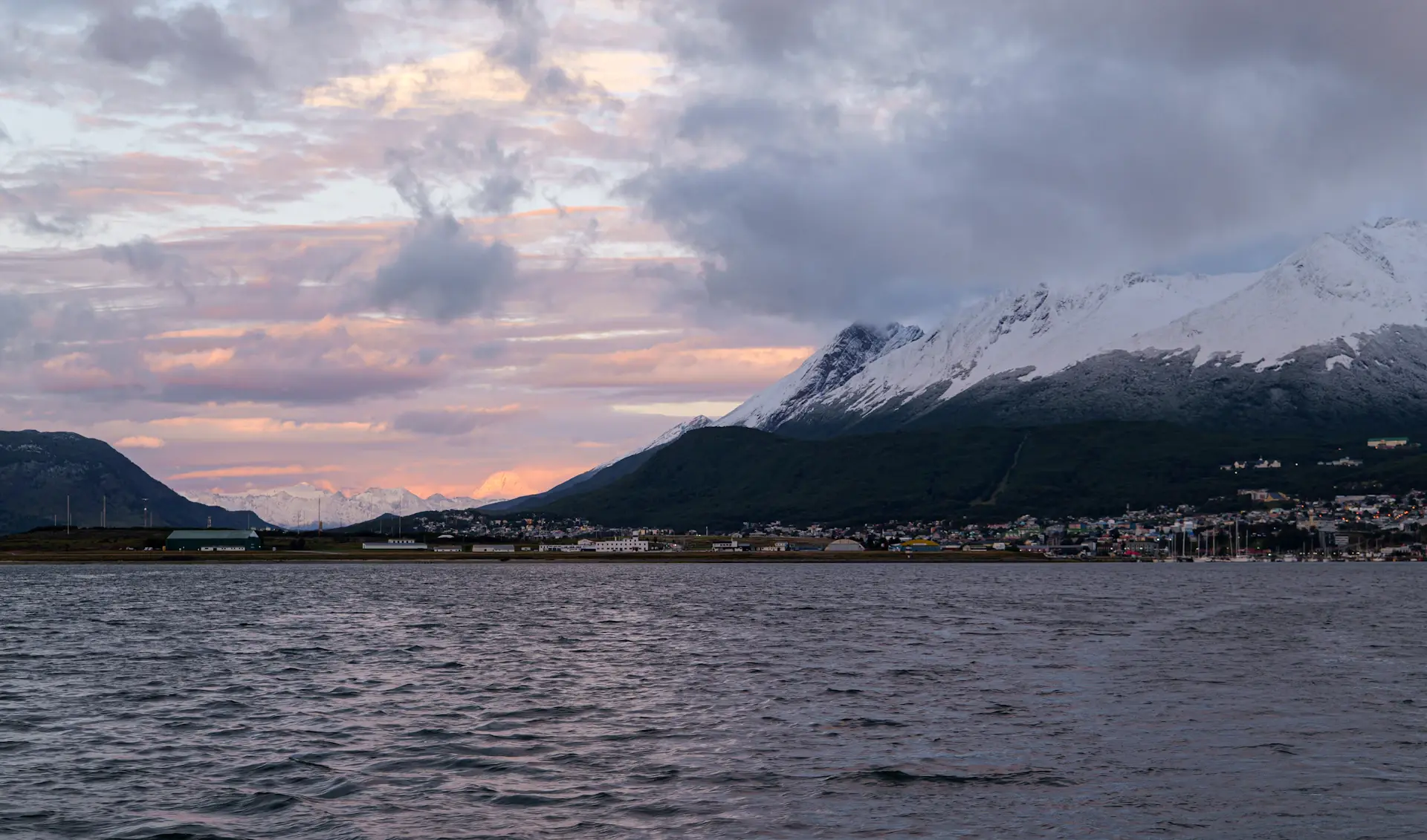 The colourful harbour town of Ushuaia at dusk beneath mountains