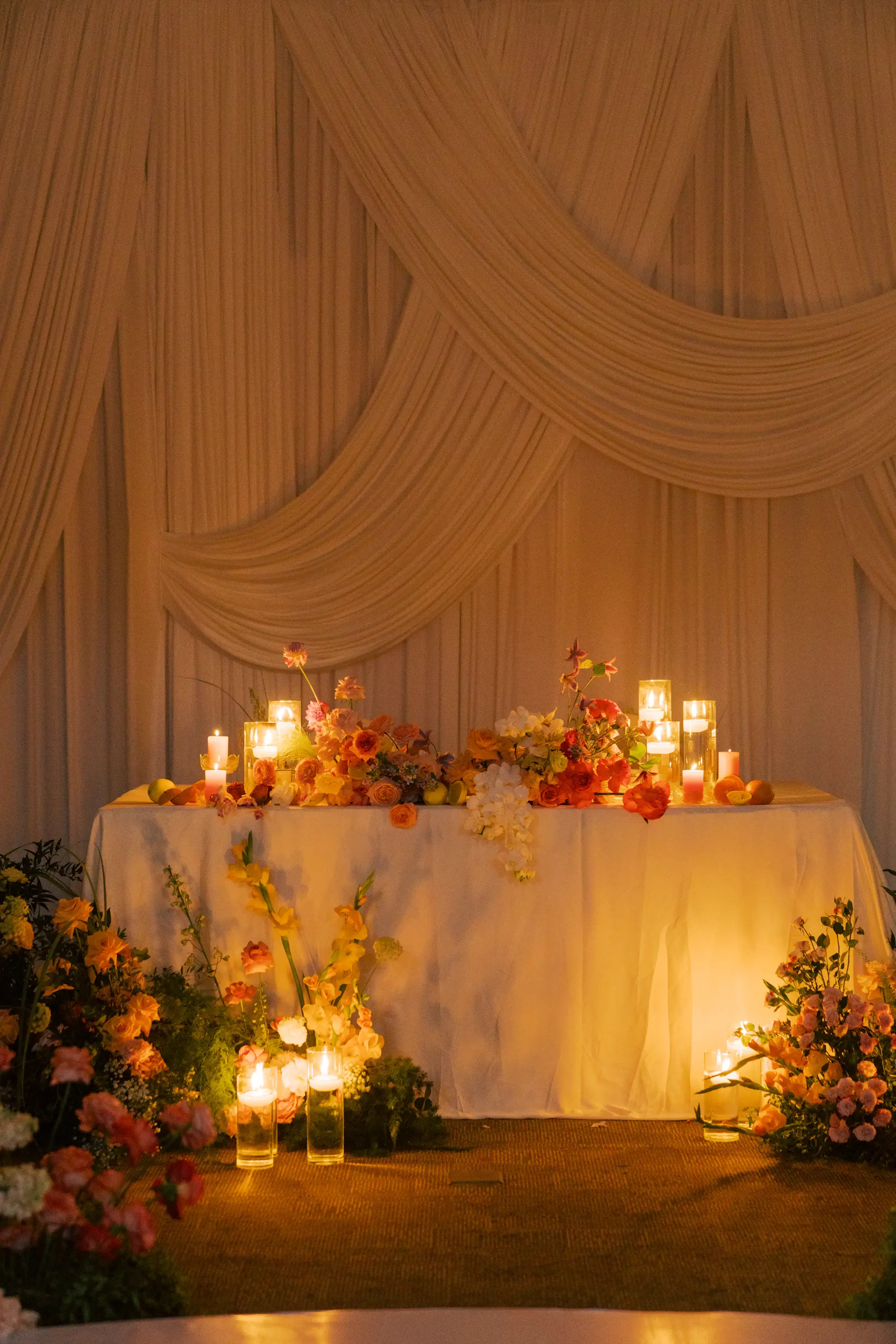 Candles being set along a reception table at dusk