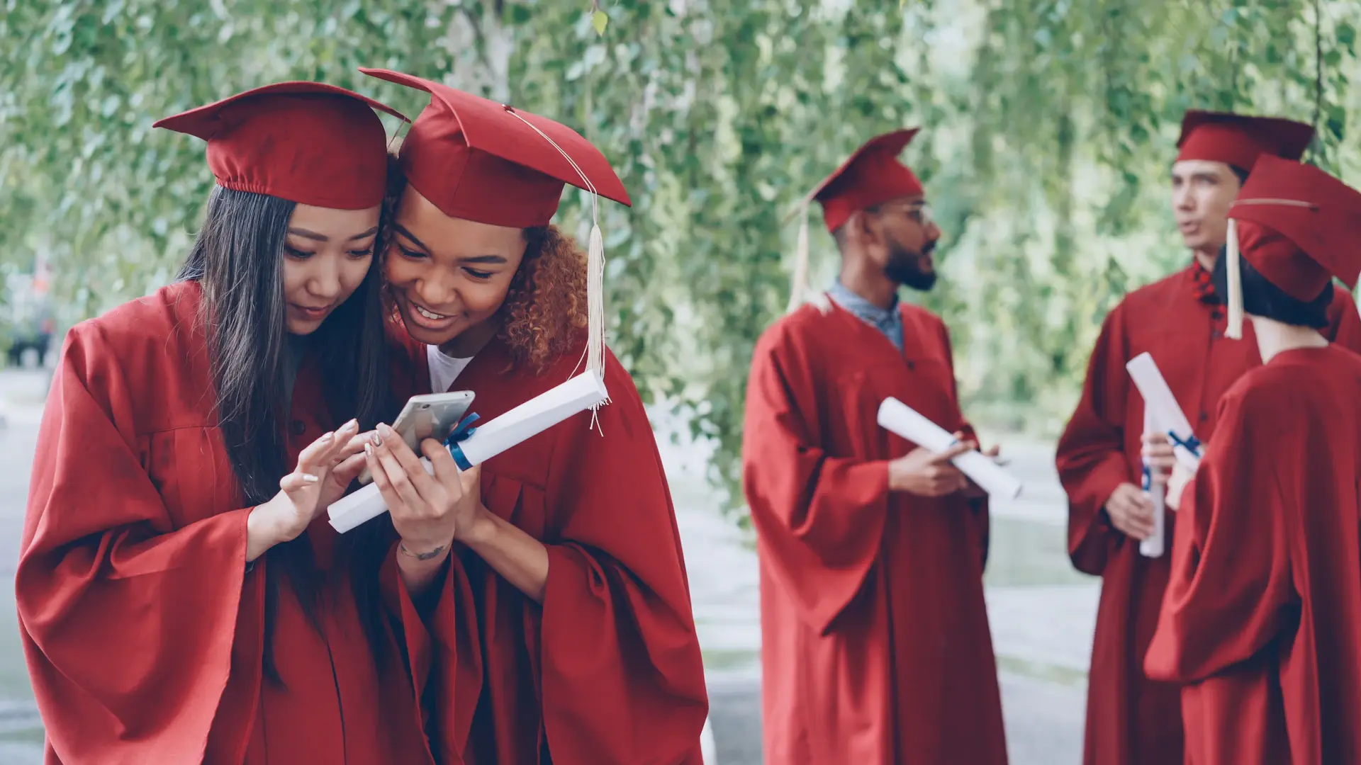 Graduate celebrating with diploma against a cinematic campus backdrop