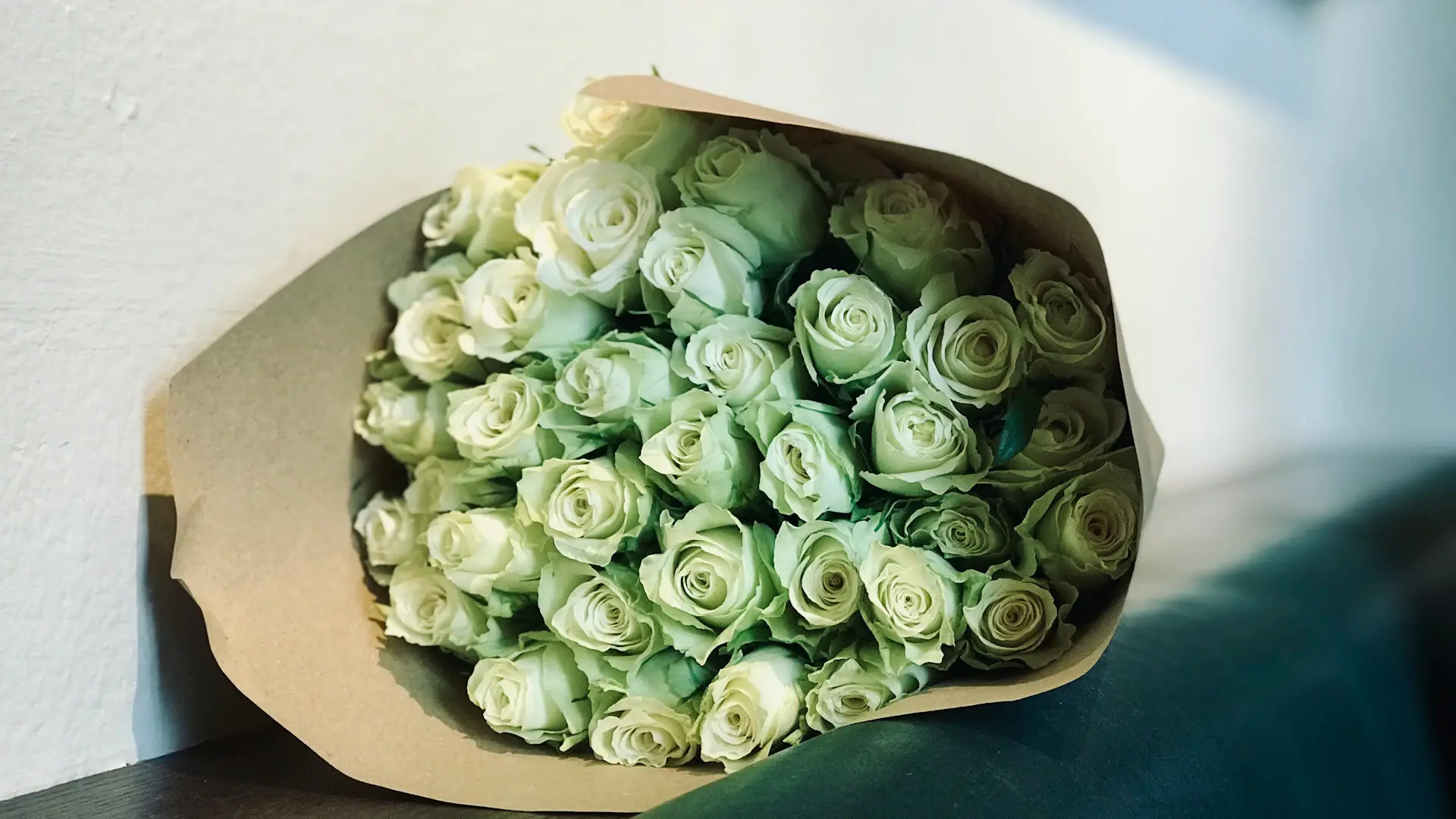 Wide cinematic still of White Bloom roses styled as a gift