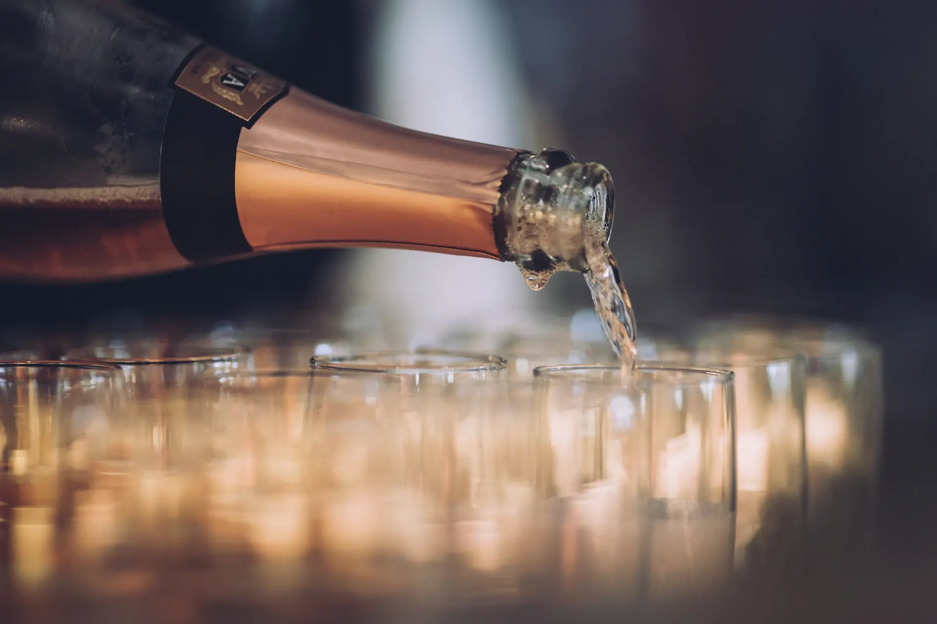 Champagne being poured into a crystal coupe with golden bubbles rising