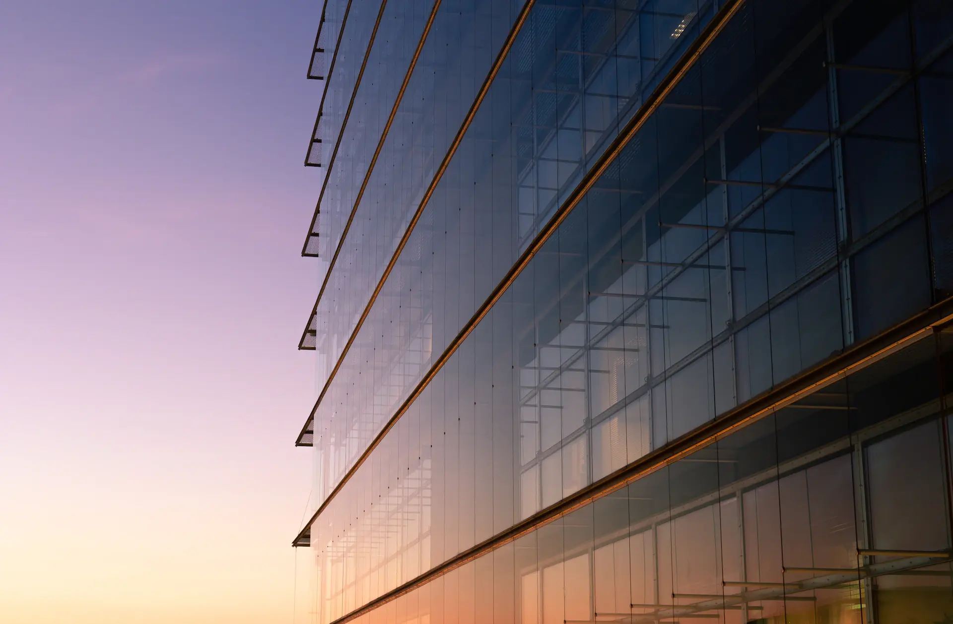 The Prestige Motors headquarters — a modern stone and glass atelier at dusk