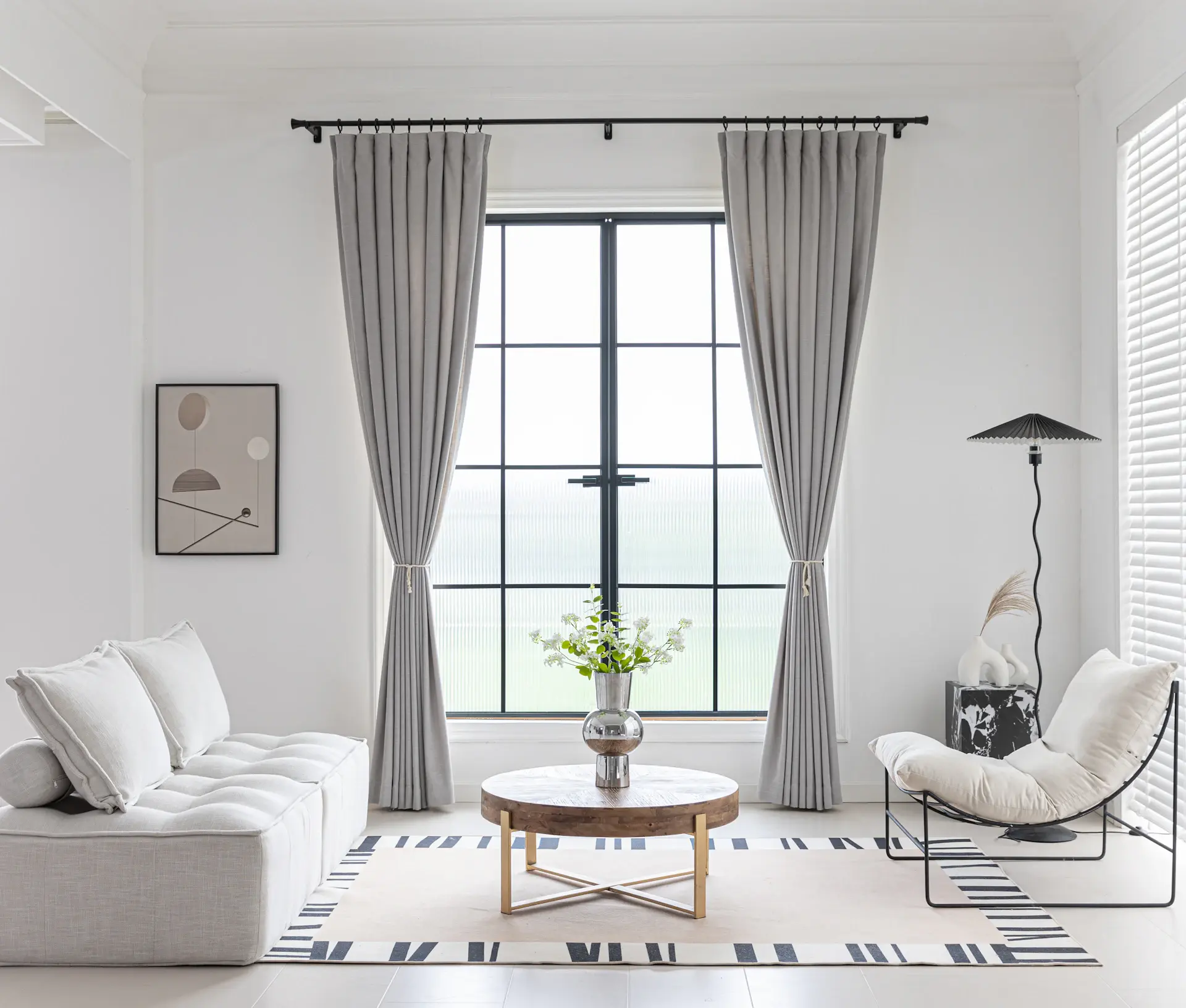 Phòng khách tối giản với ánh sáng tự nhiên đổ qua rèm vải linen