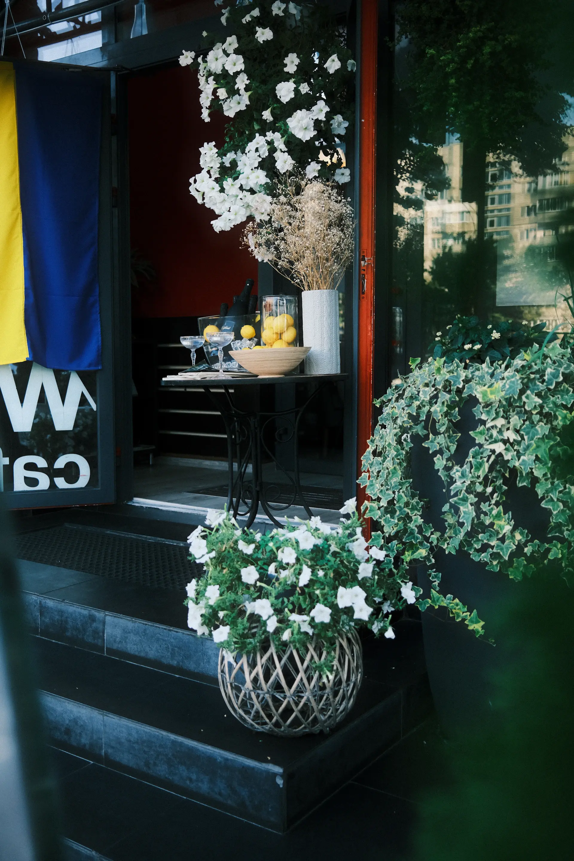 Café entrance styled with large floor plants
