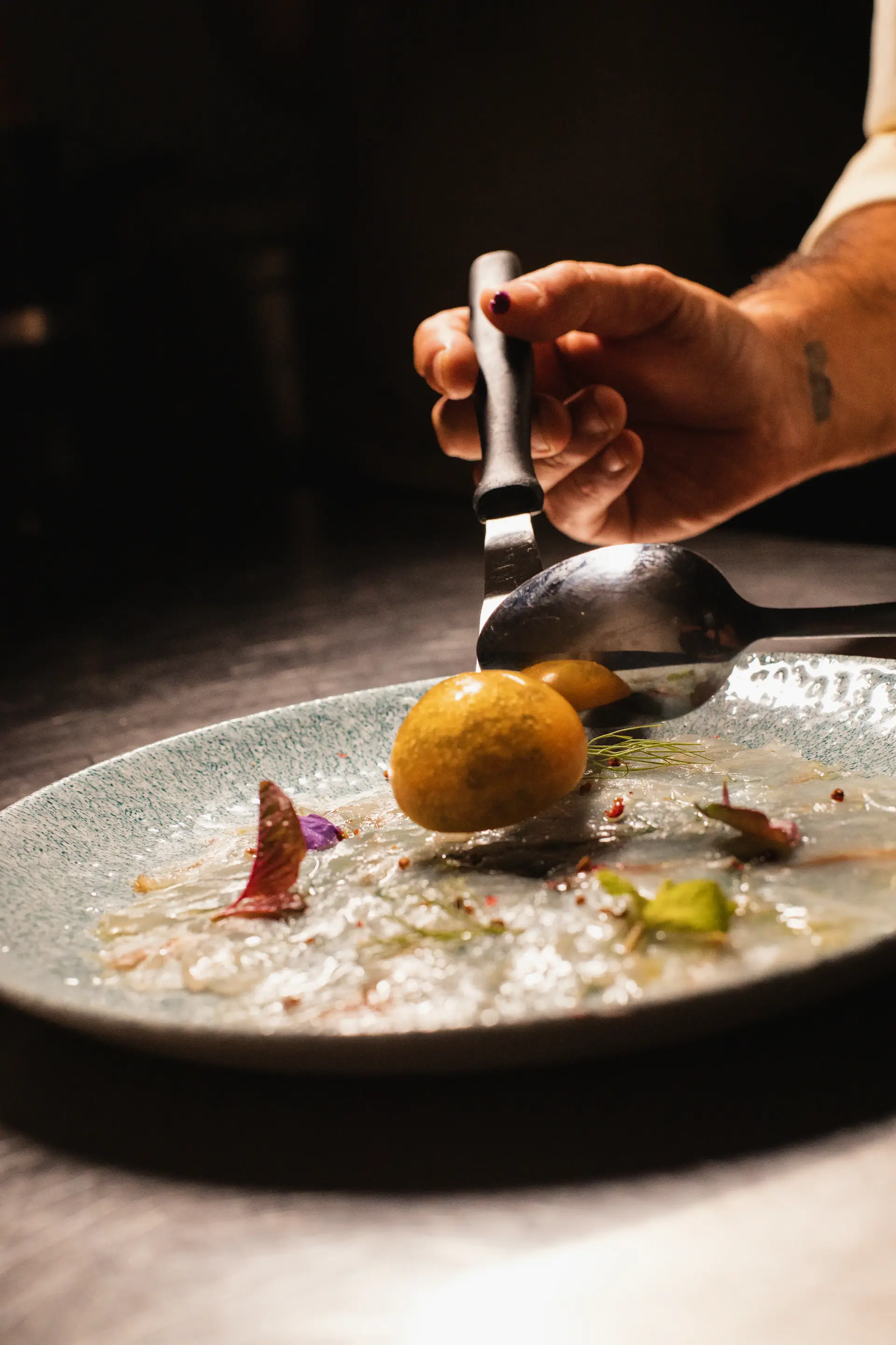 Chef plating a course in golden light