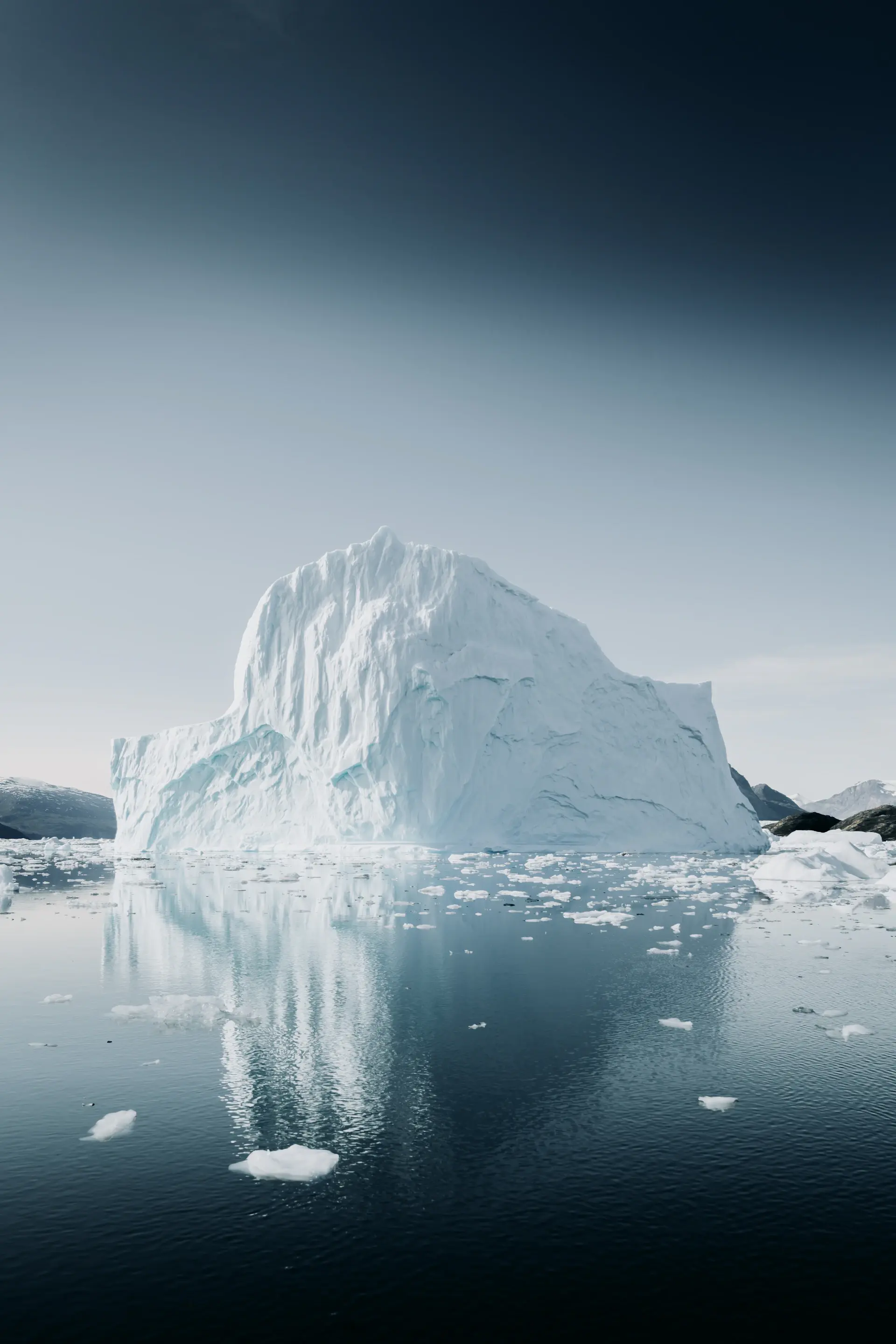 A lone expedition vessel among towering blue icebergs