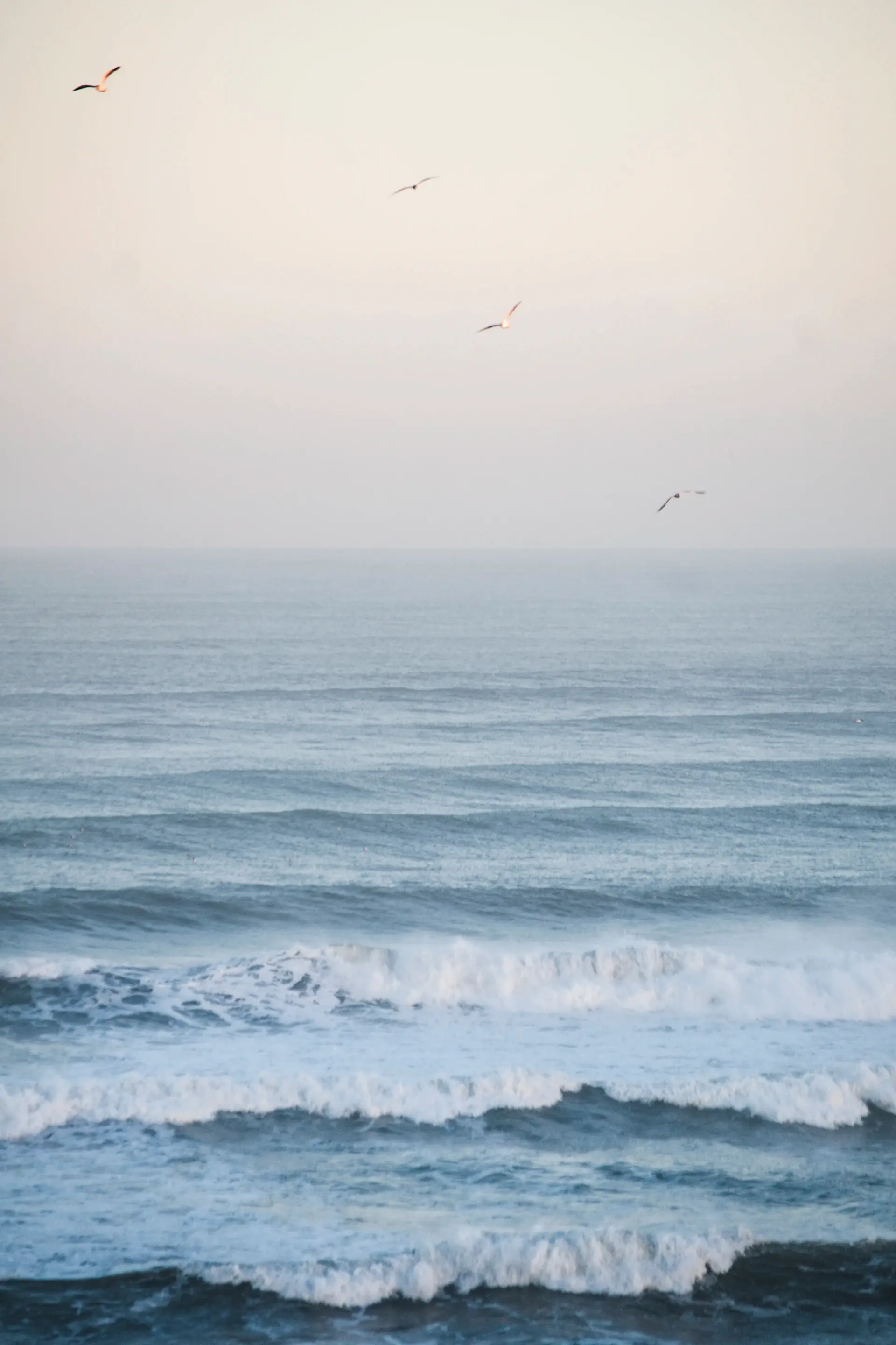 Soft waves smoothing ripples on a pale empty shore