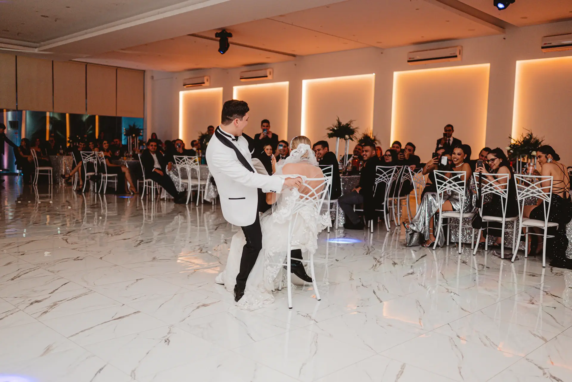 Couple sharing a first dance under warm lighting