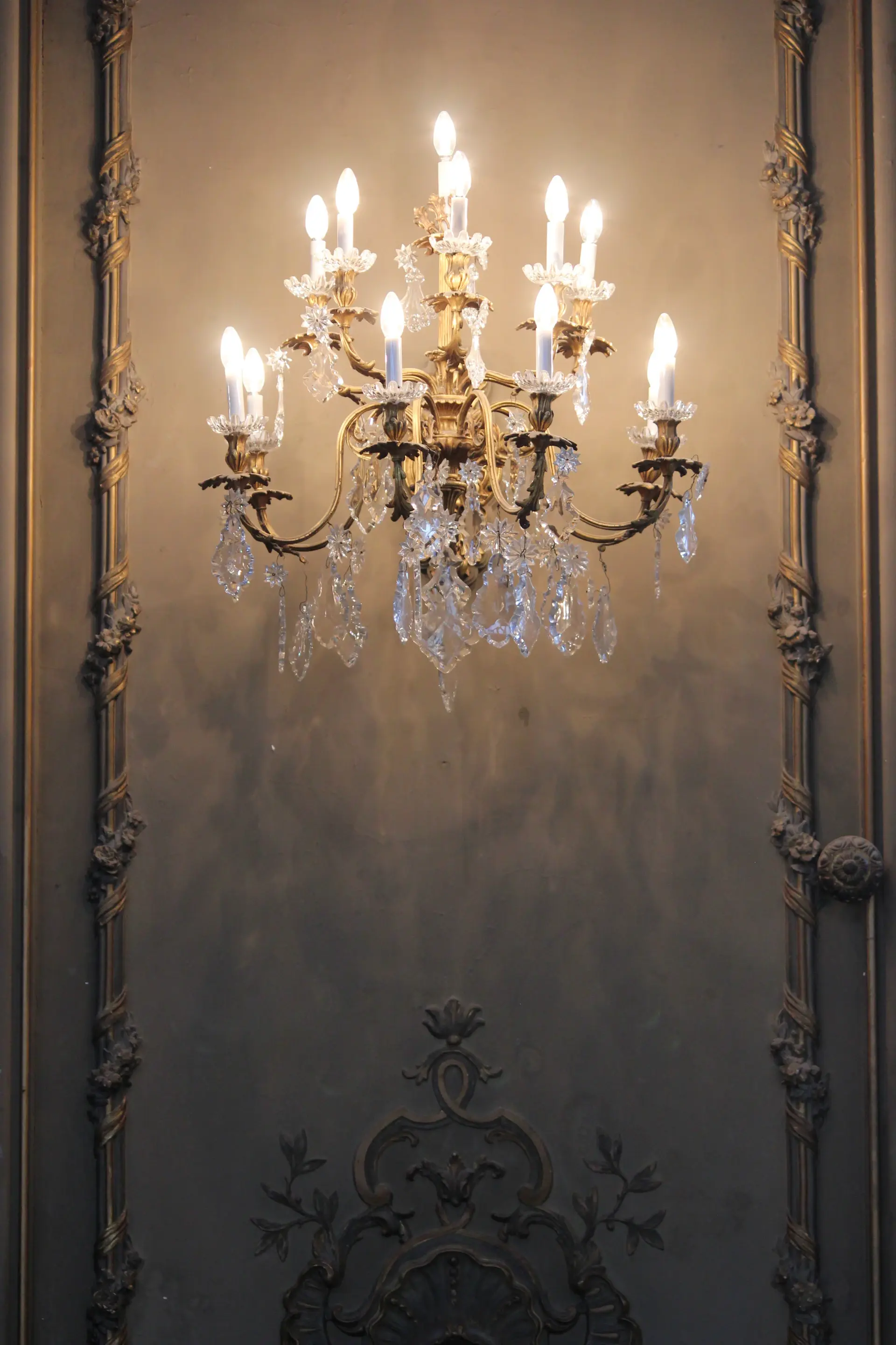 Crystal chandeliers glowing above a candlelit ballroom