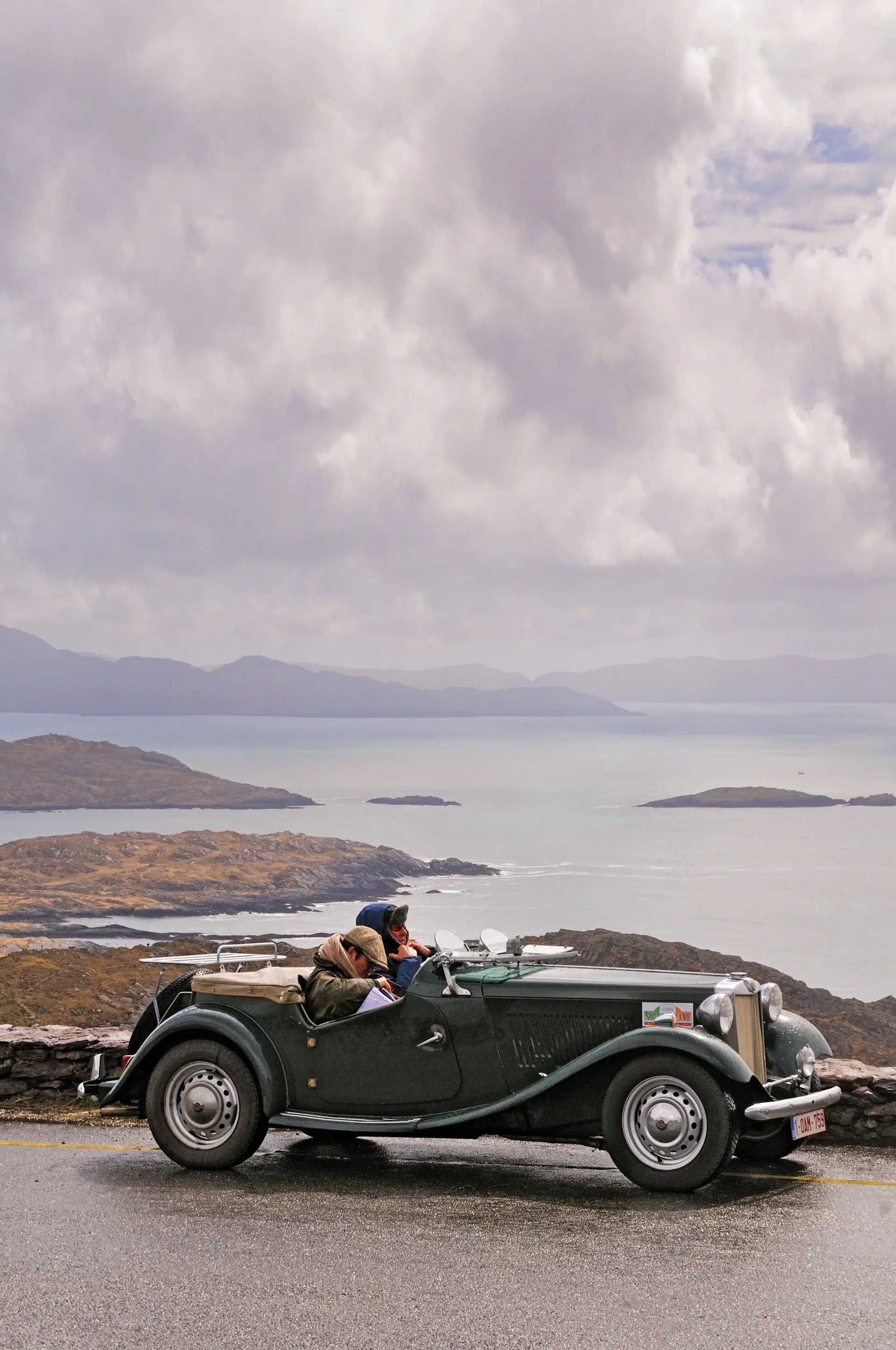 A classic motorcar on a winding coastal road