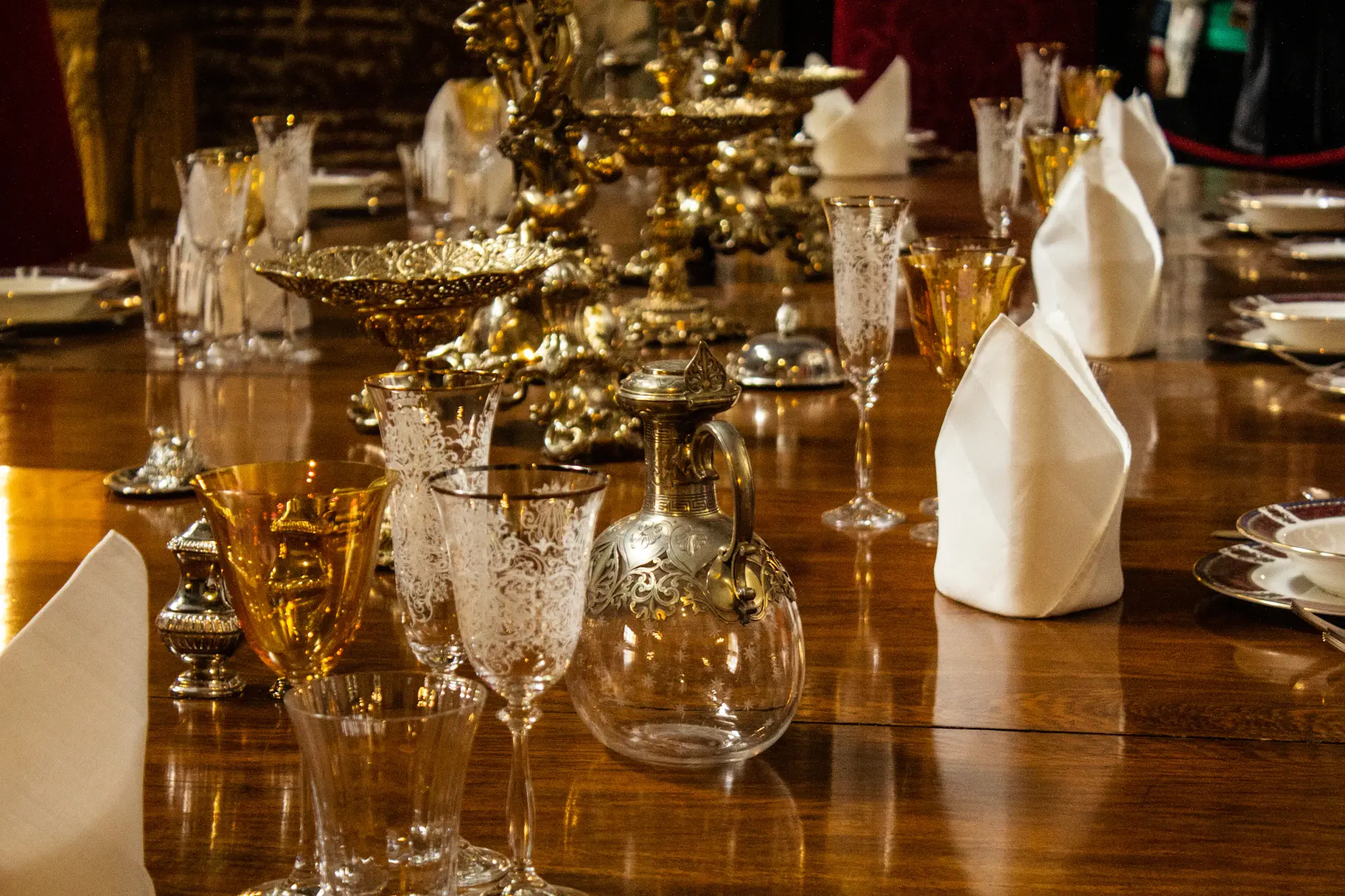 An elegantly set banquet table glowing under candlelight