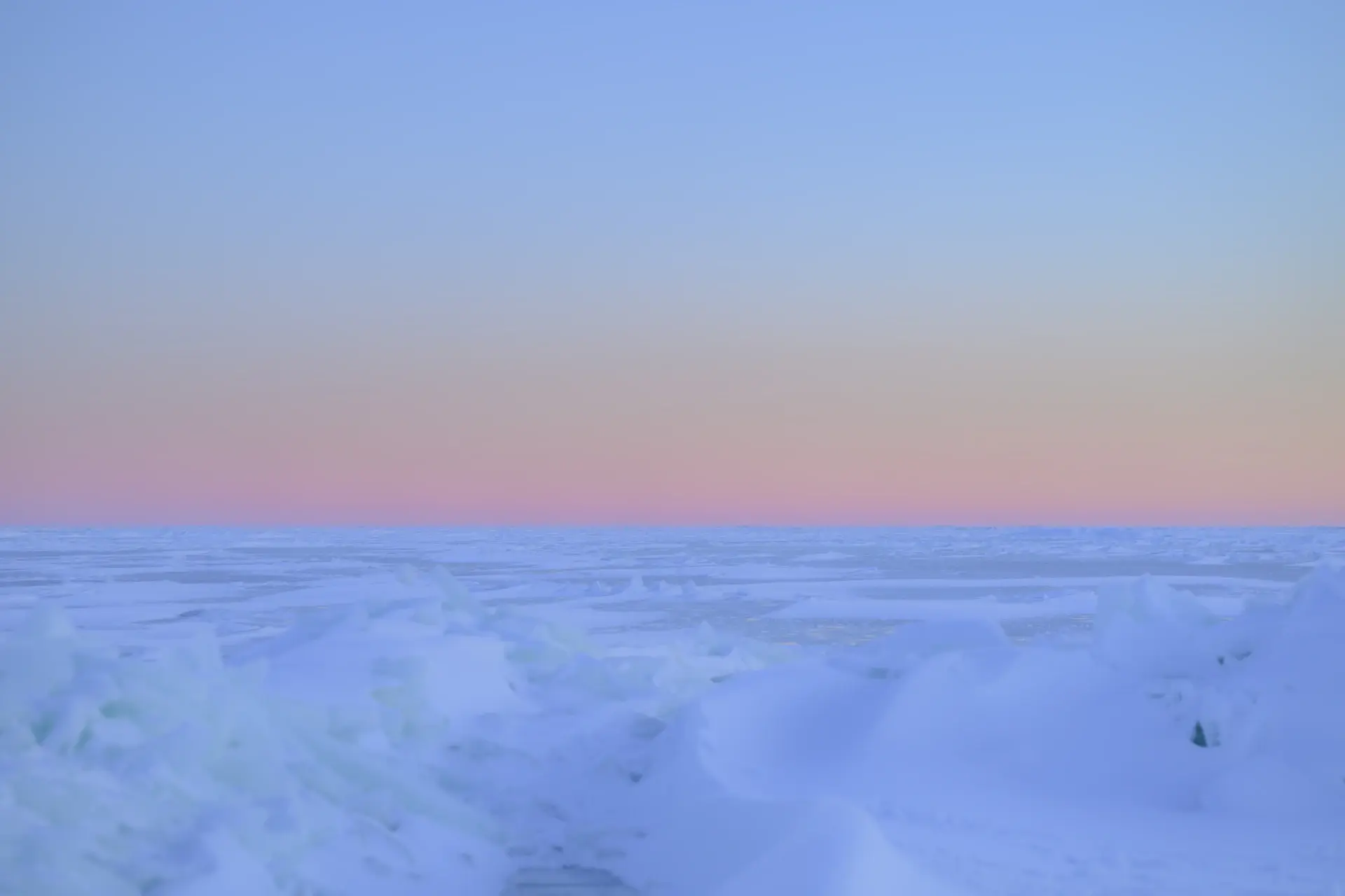 Towering blue glacial walls under a pale arctic sky