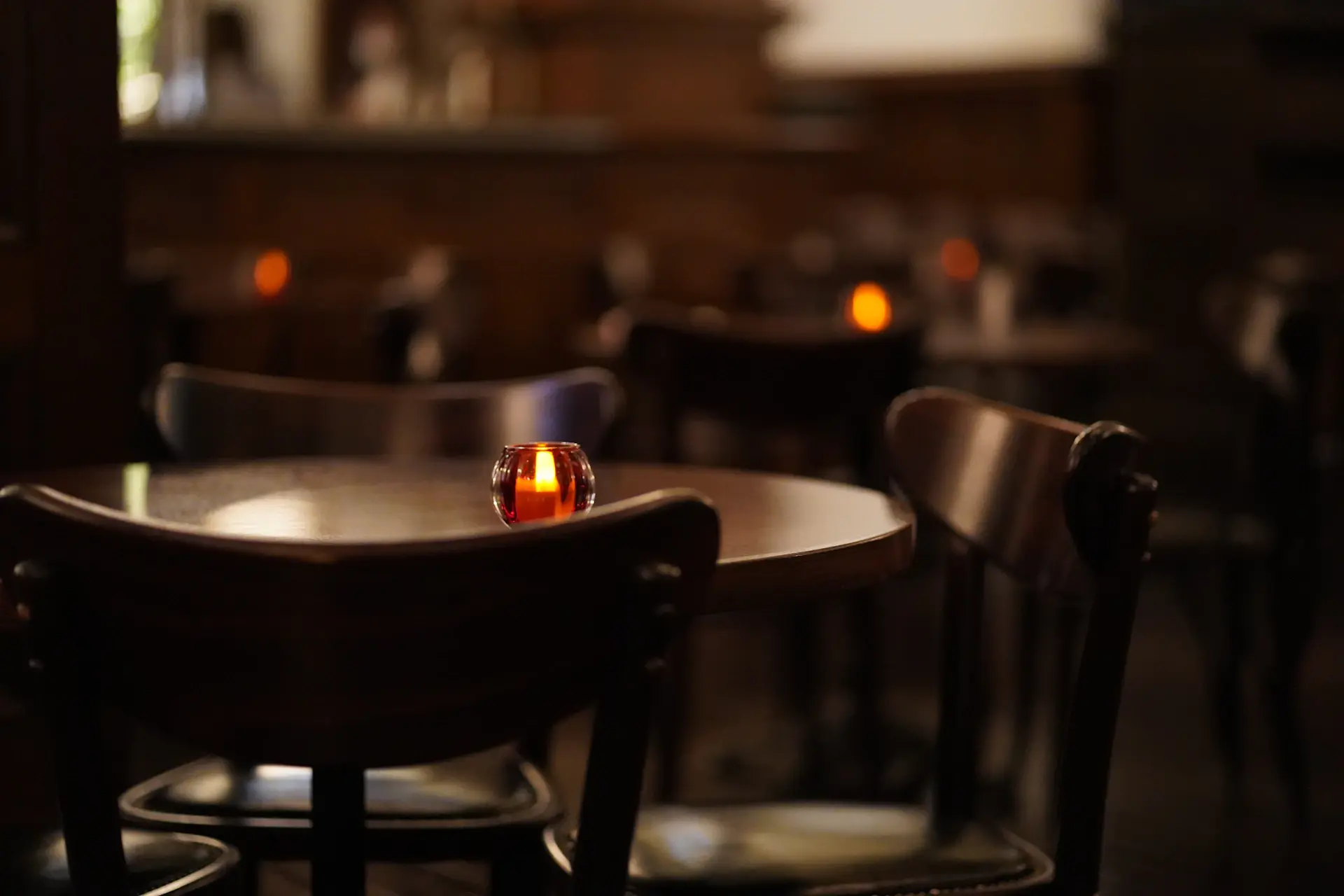 A plated fine-dining tasting course beside a glass of champagne in candlelight