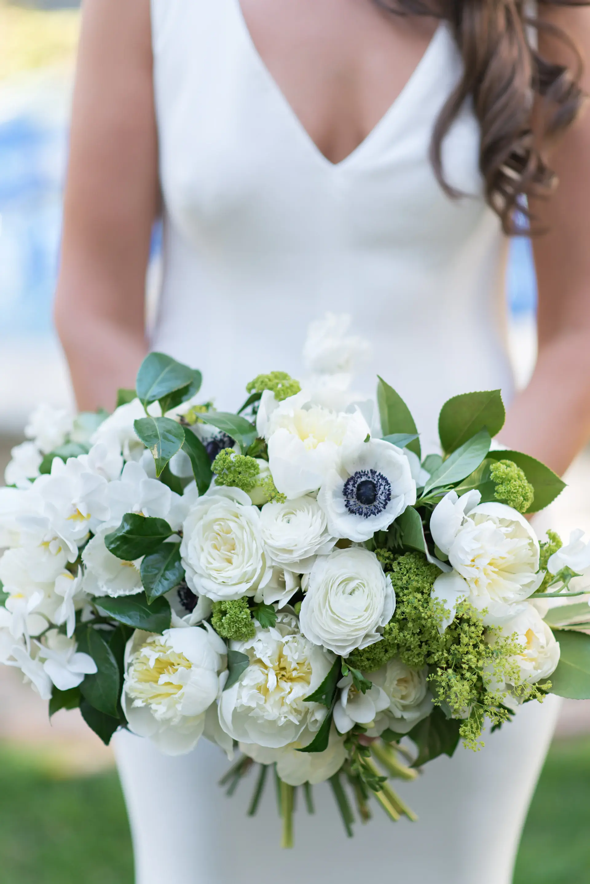Florist arranging a bridal bouquet of ivory blooms