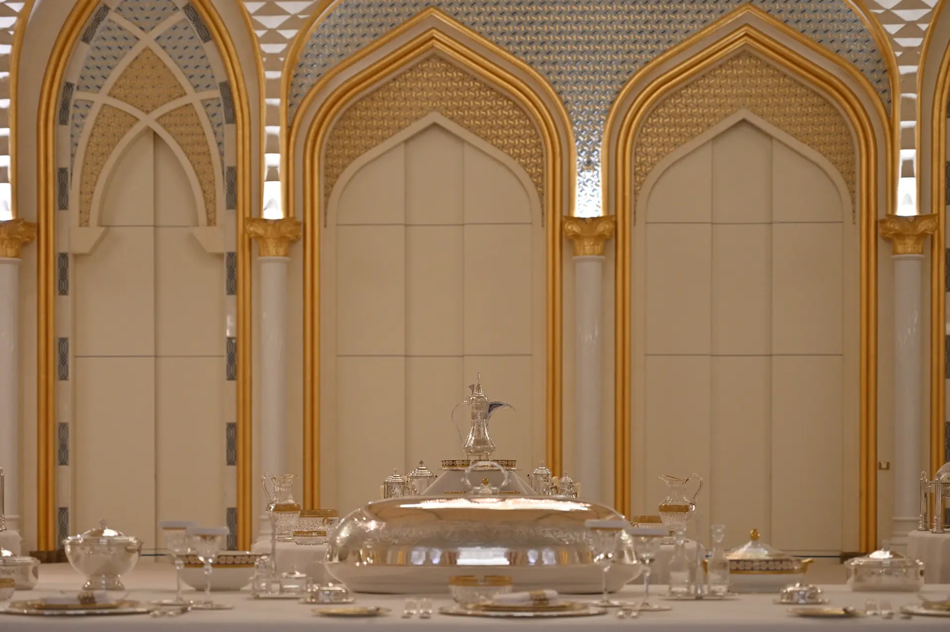 Ivory rose centrepiece on a gold-set banquet table