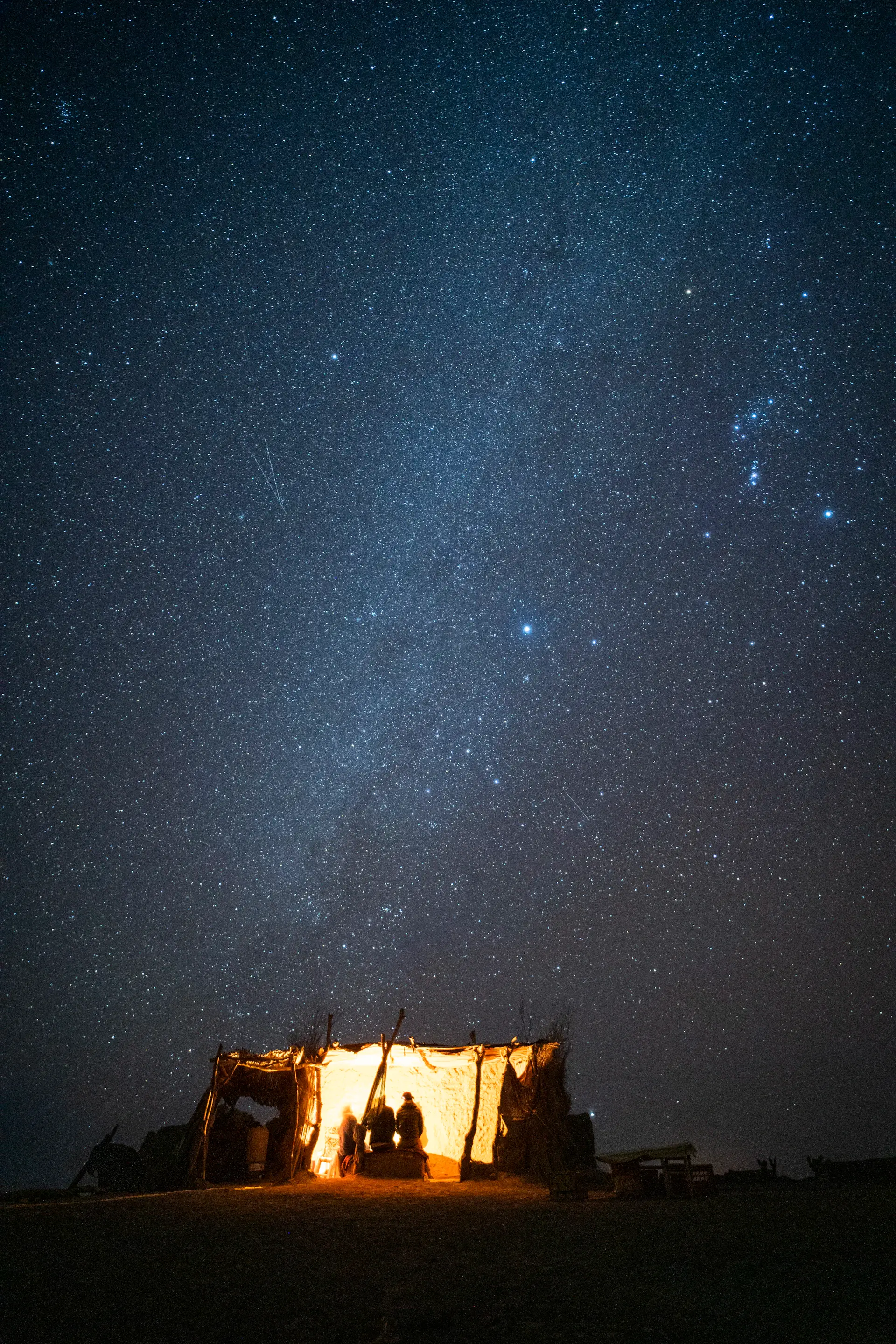 Solitary tent beneath a star-filled desert sky