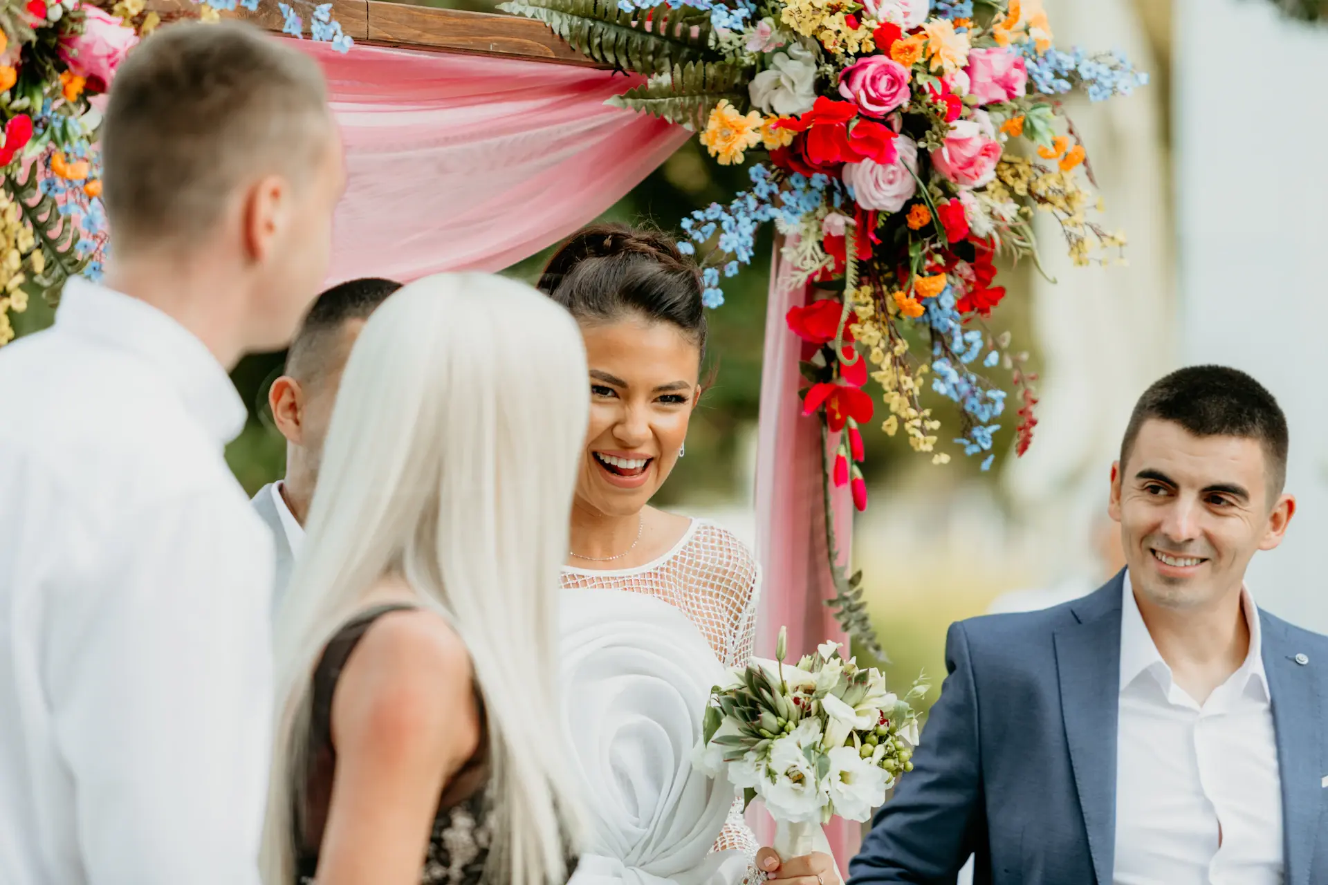 Couple exchanging vows under a floral arch