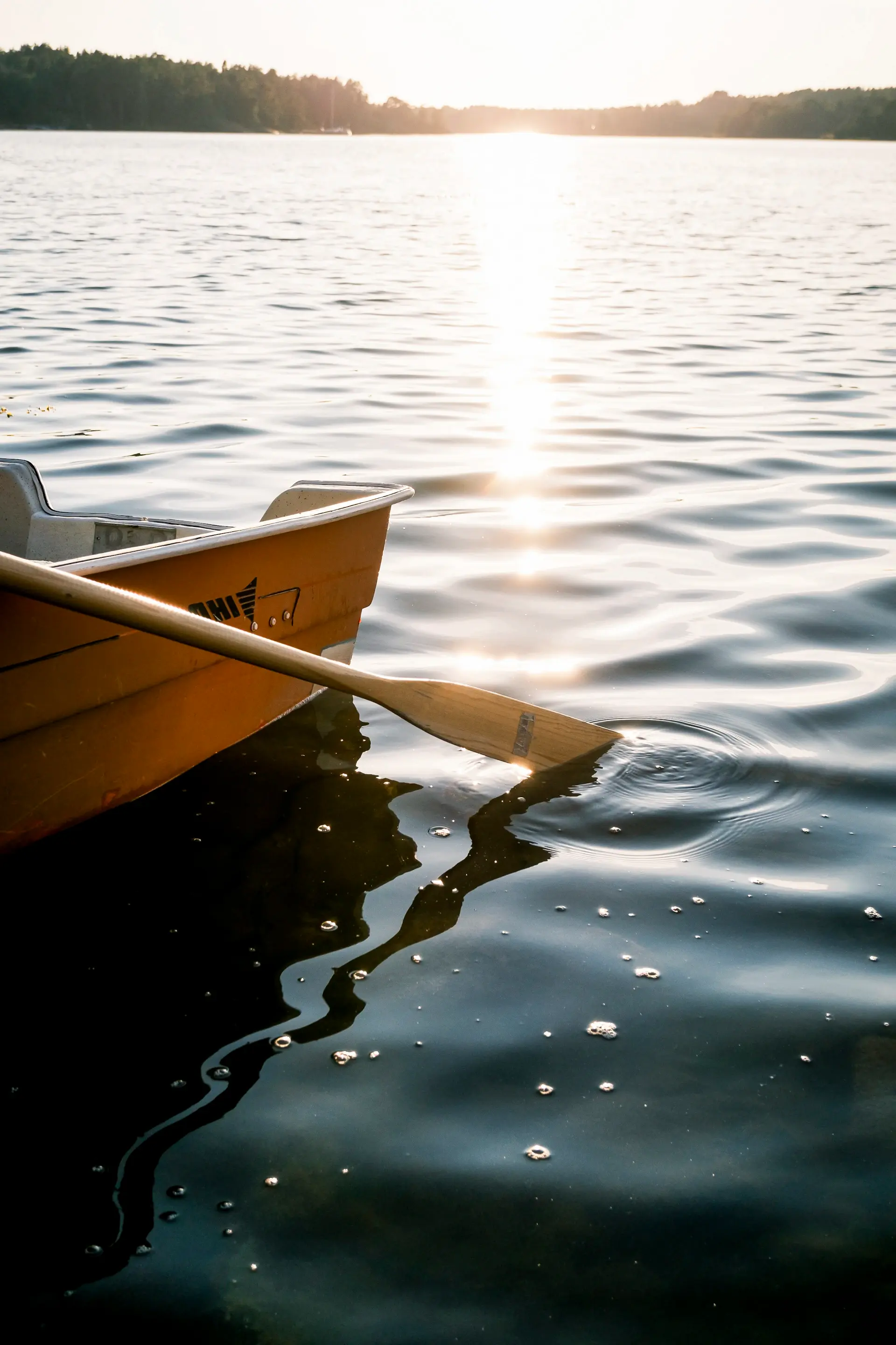 A single rowboat resting on a calm lake