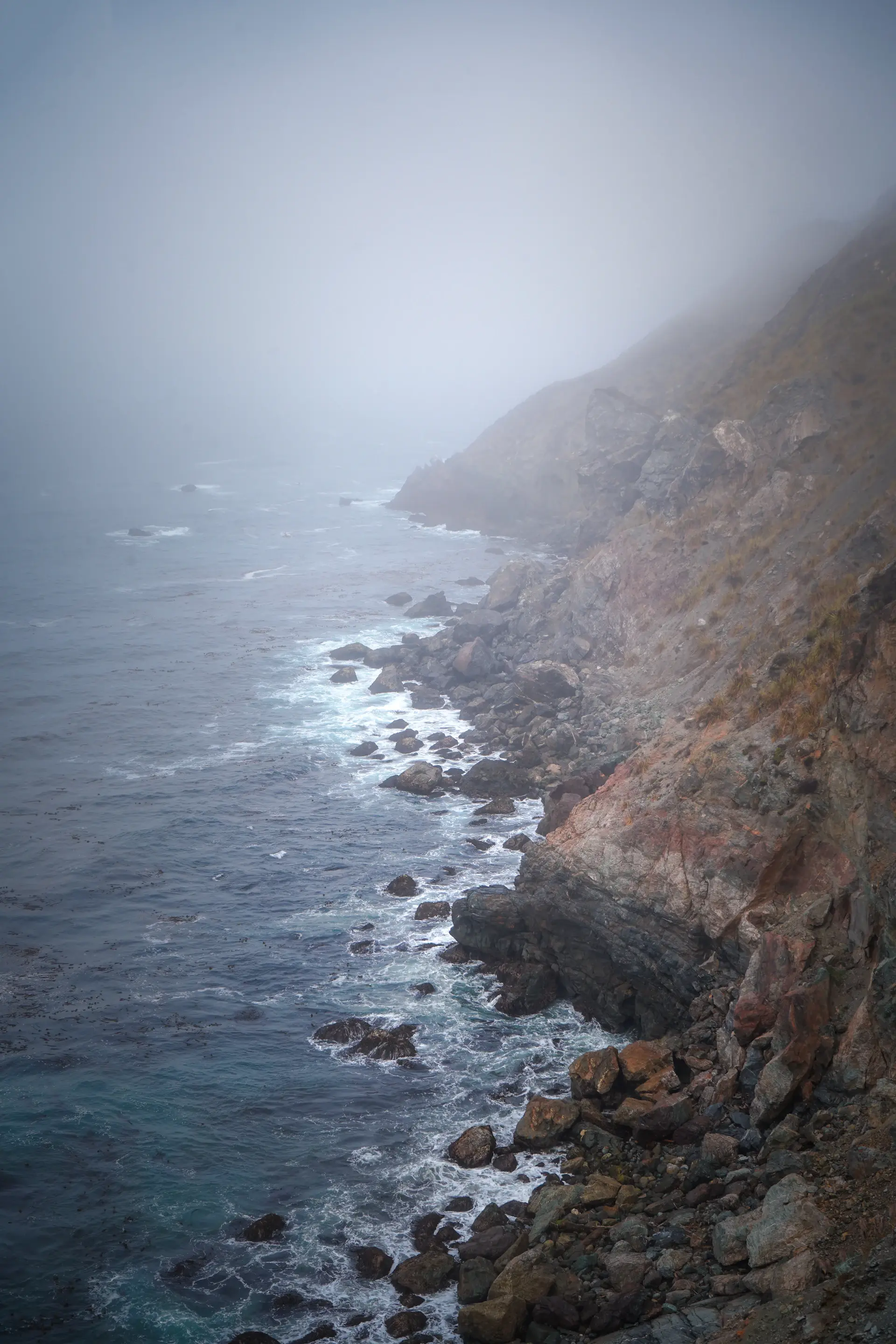 Fog drifting over a wild rugged coastline