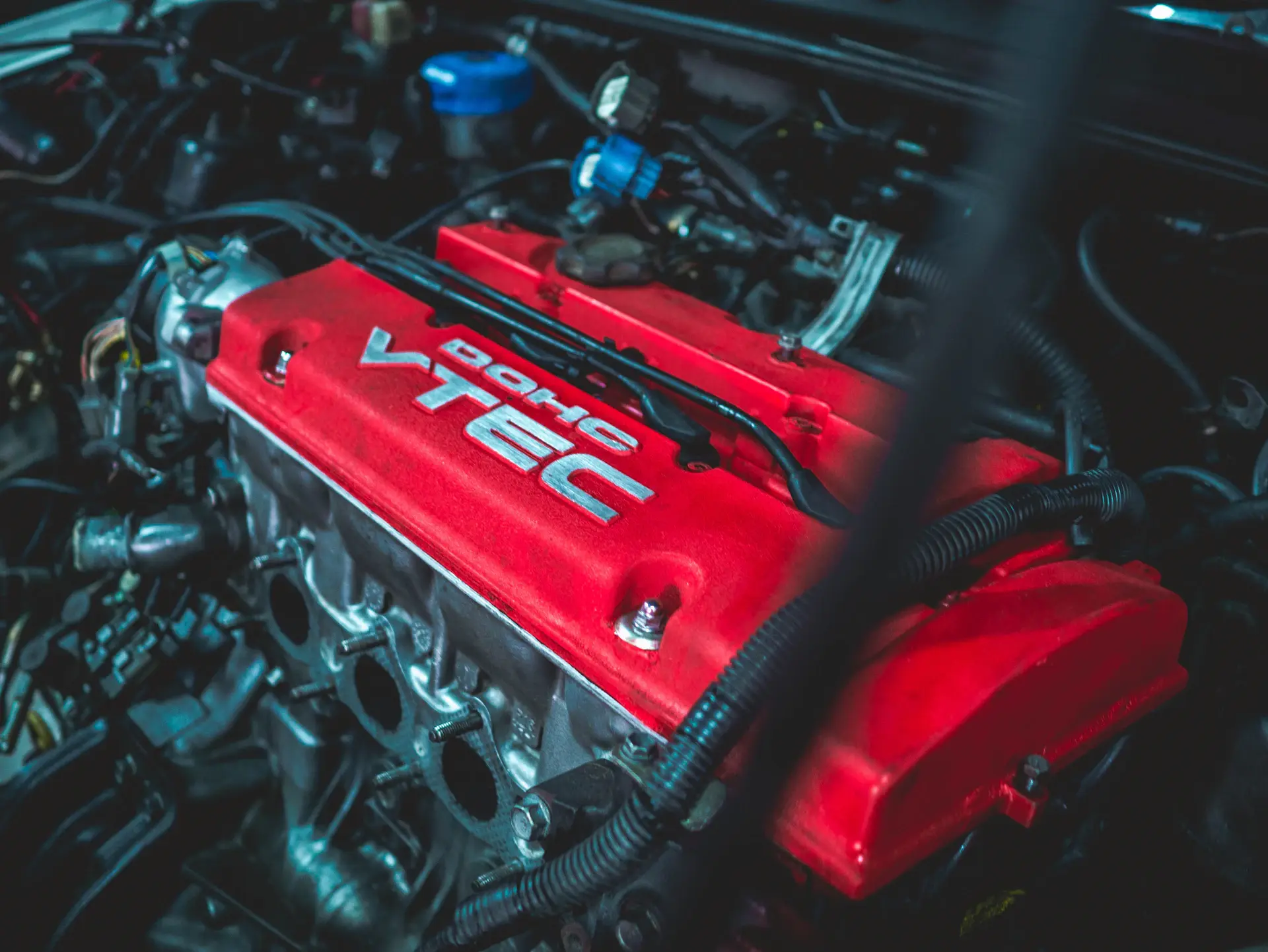 Close cinematic detail of a hand-finished V12 engine and engraved badge