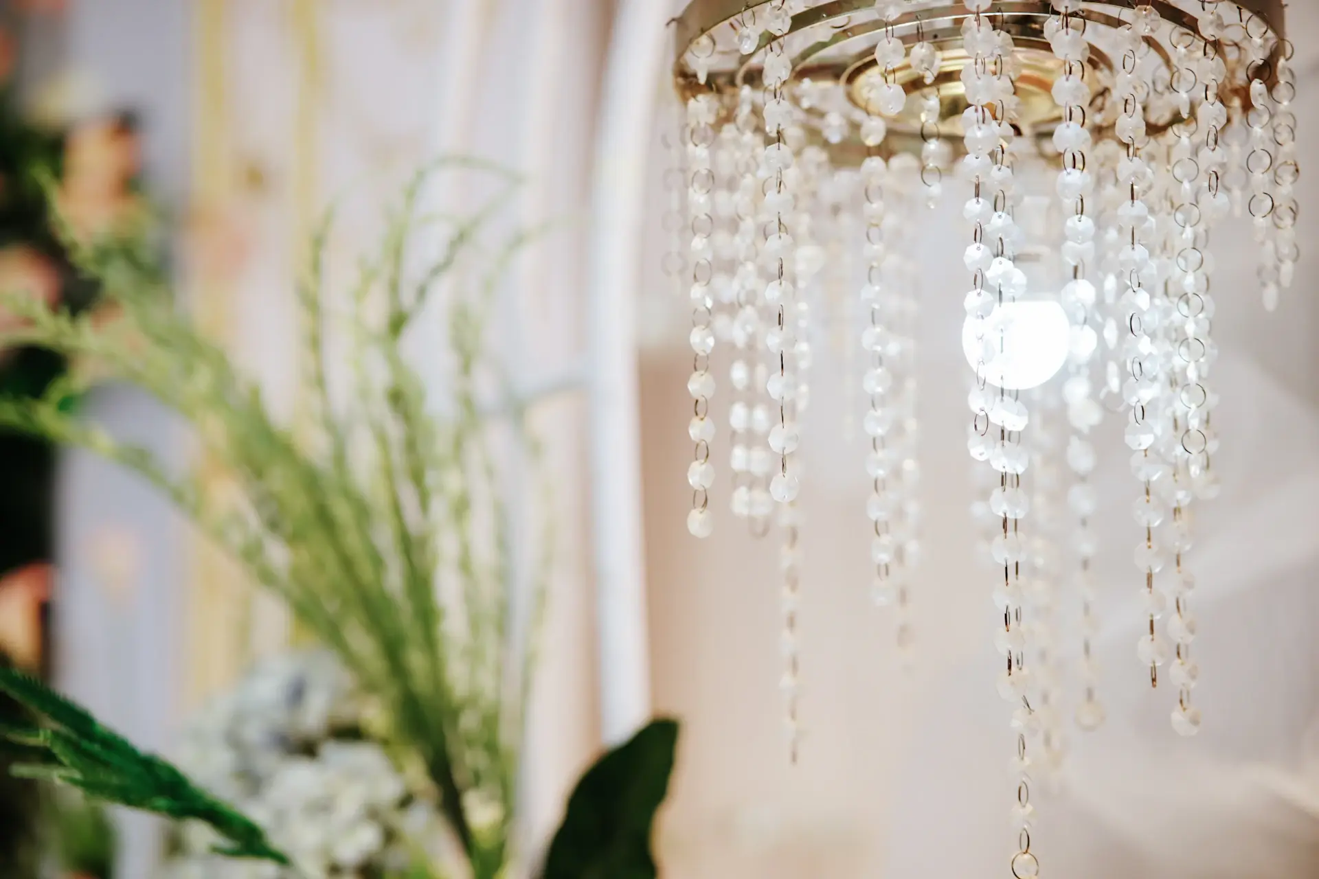 Bride and groom dancing beneath a grand chandelier