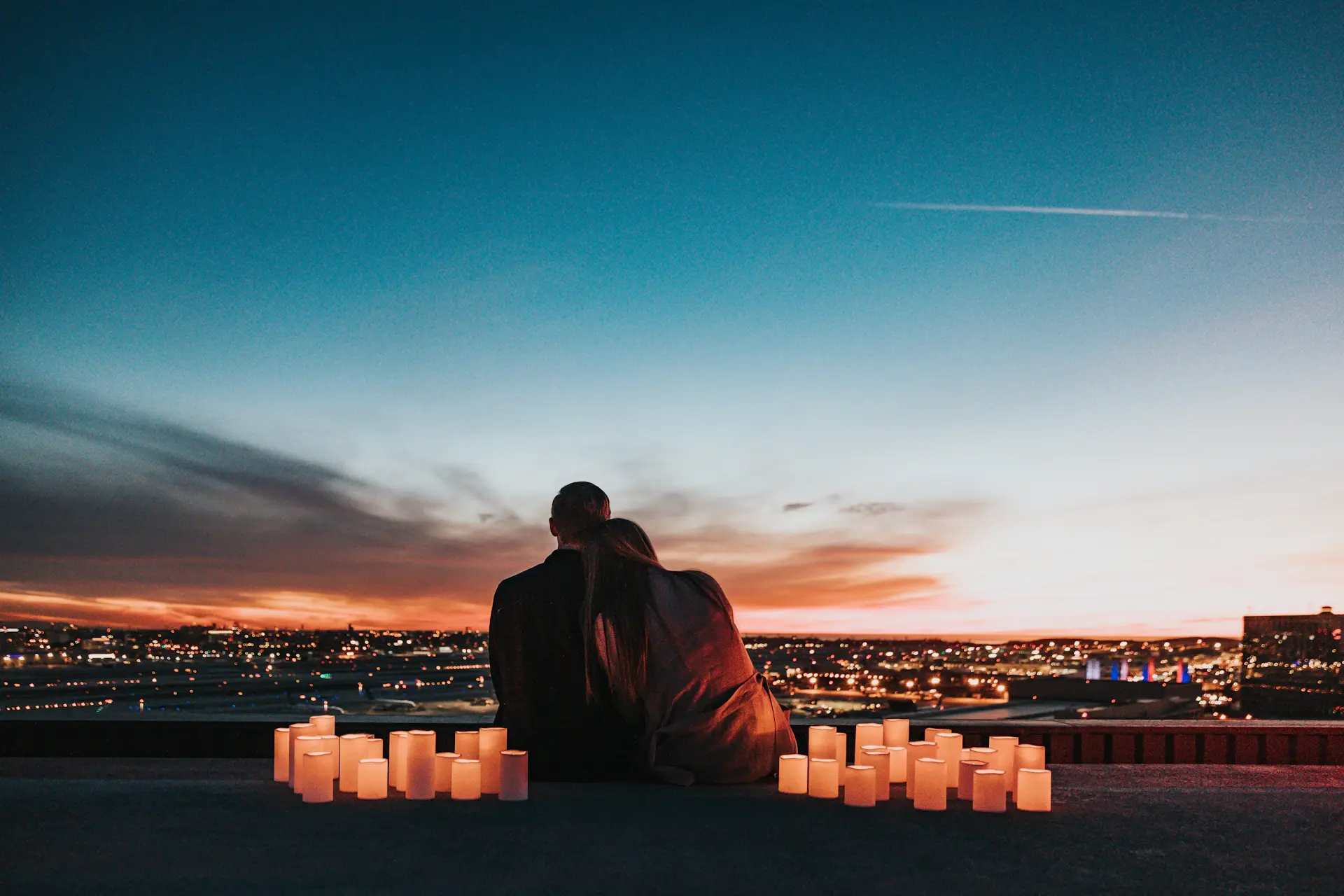 Couple beneath the illuminated grand ballroom at dusk