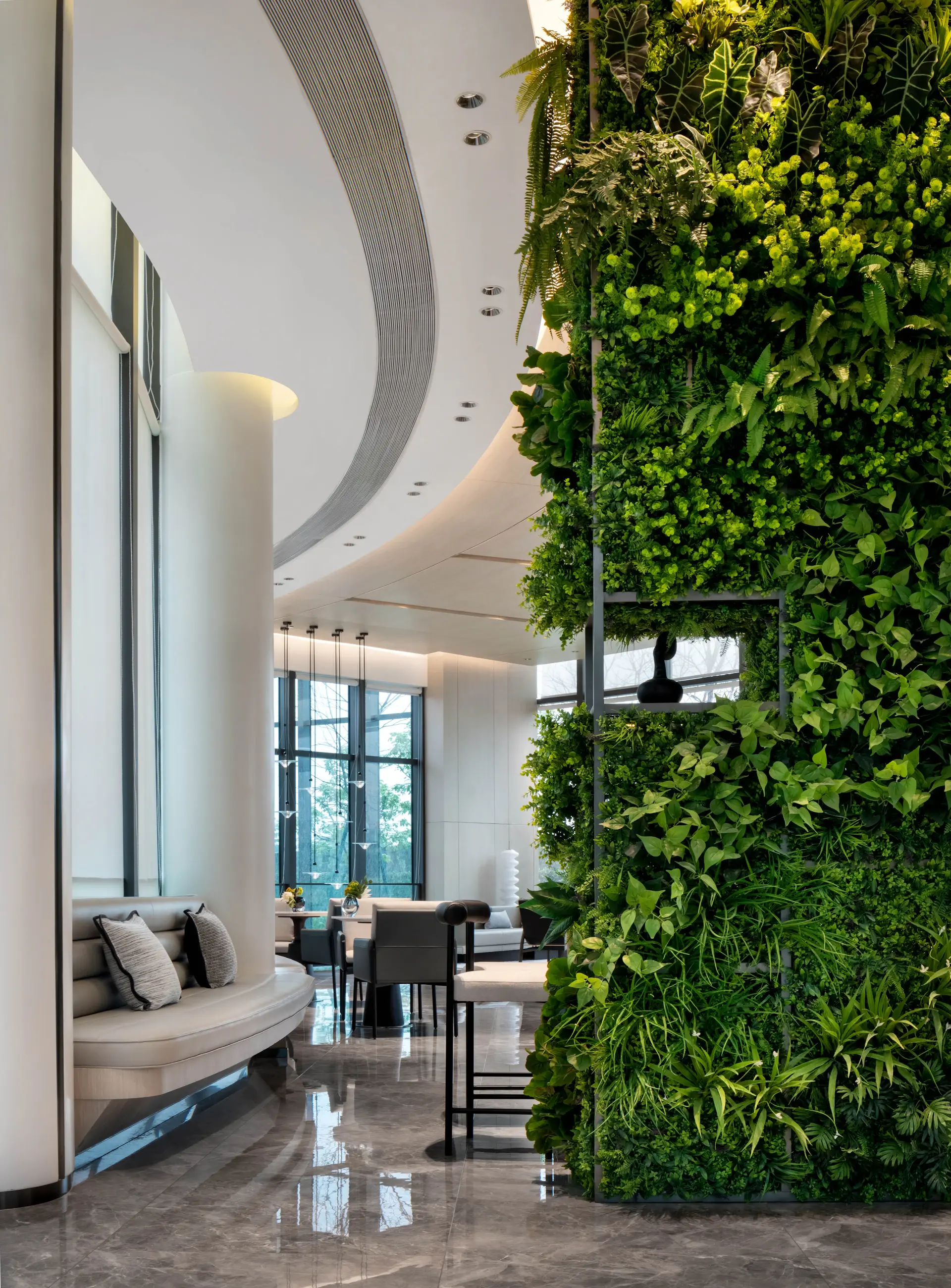 A styled office lounge layered with large indoor plants and trailing greenery